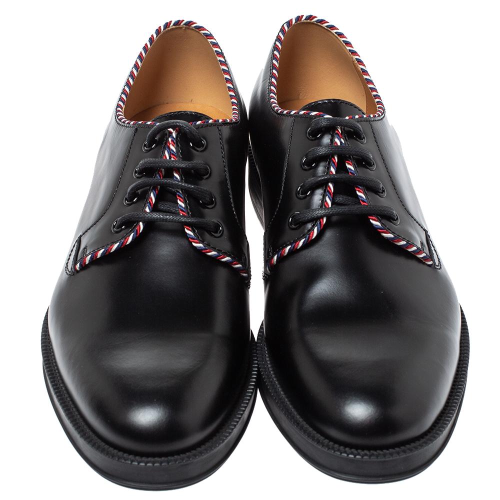 Be the sophisticated statement maker in a smart-casual outfit with this pair of derby shoes from the house of Gucci. Designed from sleek black leather, this pair features a lace-up detail, tri-colored rope trims, and can be teamed with your dressy