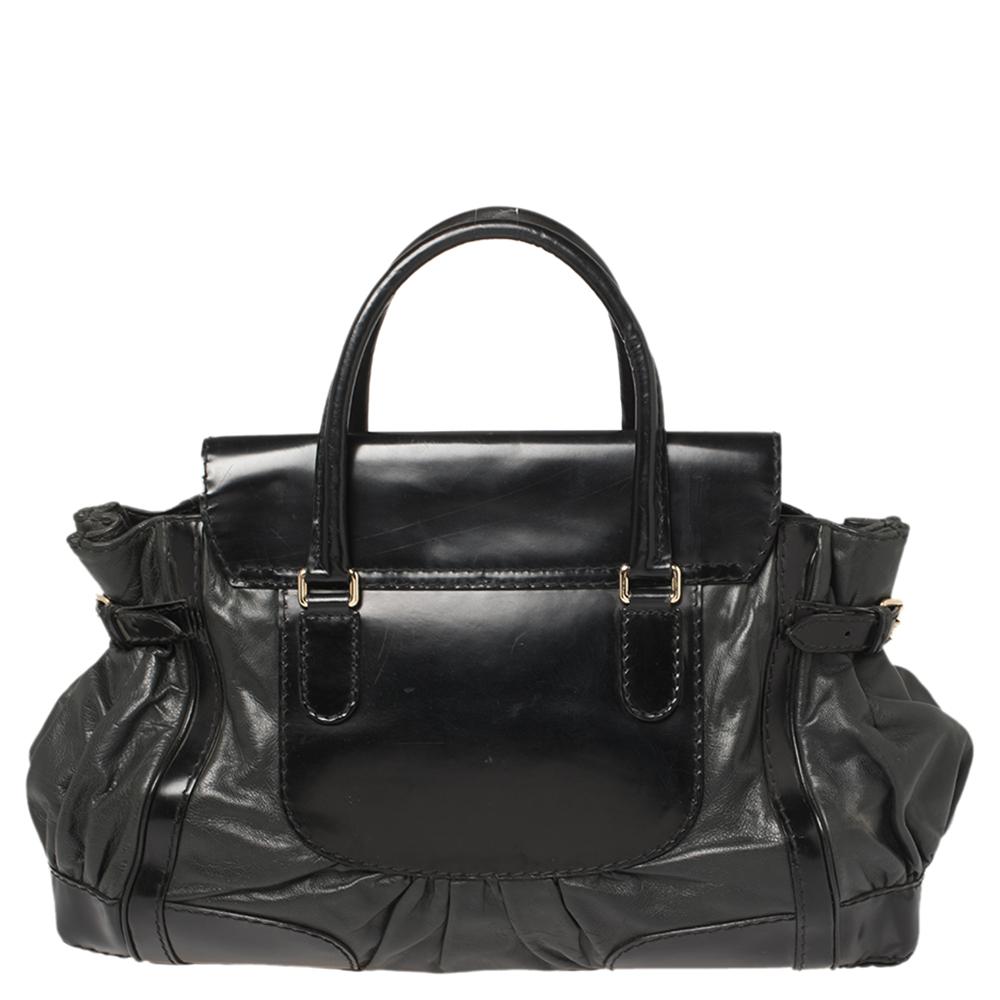 Go sophisticated with this black Queen tote by Gucci. Crafted from coated canvas & leather, it is detailed with distinctive stitching, a bow-shaped closure, and comfortable rolled leather handles. Its large interior is lined with nylon and comes