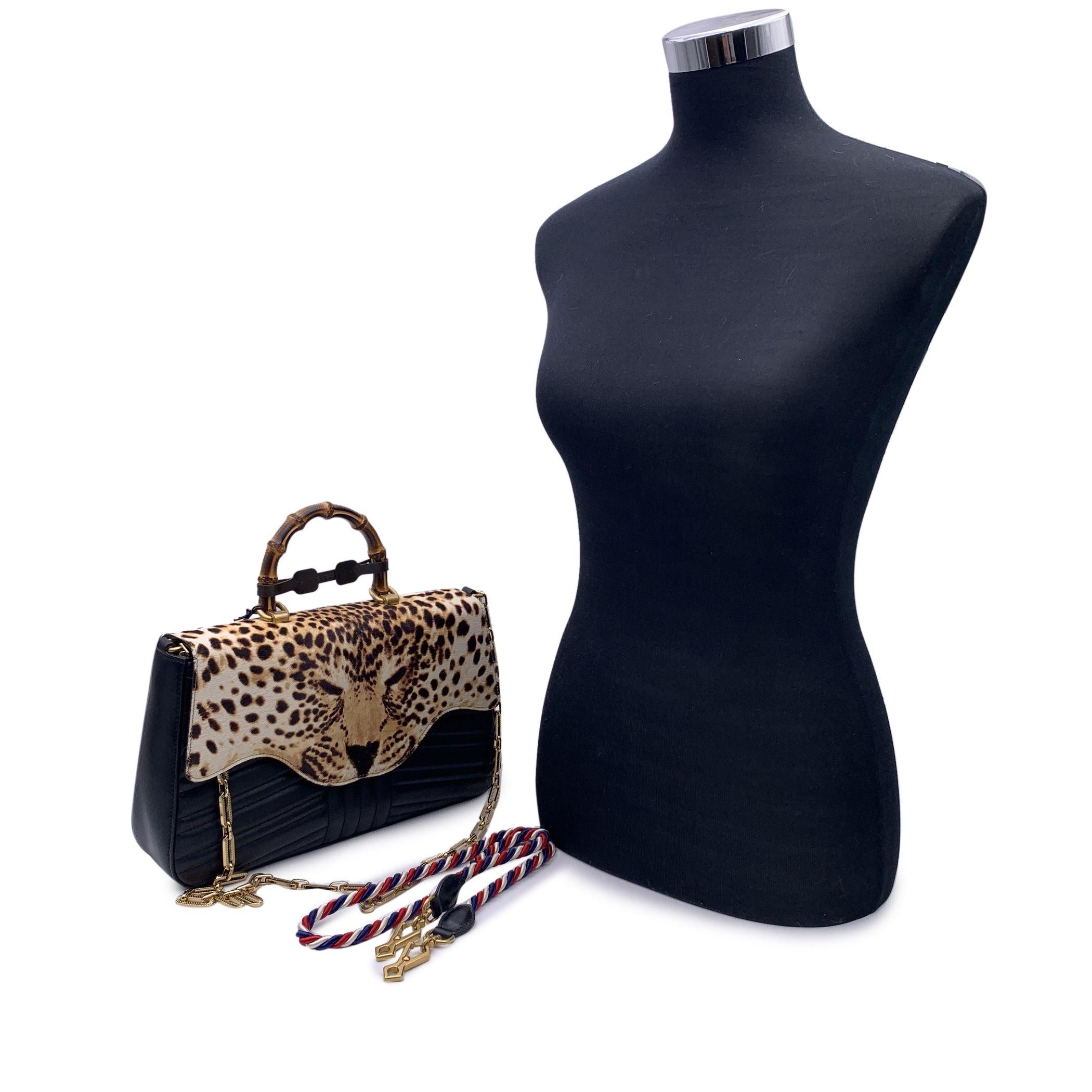 Bellissima borsa Gucci Bamboo con manico superiore. Pelle nera trapuntata con patta in pelo di vitello stampato leopardo. Ferramenta in metallo dorato. Chiusura a pressione. Tracolla a catena in metallo dorato e tracolla a treccia rimovibile blu,