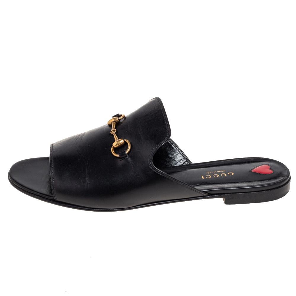 Experience both comfort and signature style with these Malaga slides from the House of Gucci. They are made from black leather with a gold-toned Horsebit embellishment perched on their vamps. They feature an easy slip-on style. Complement your