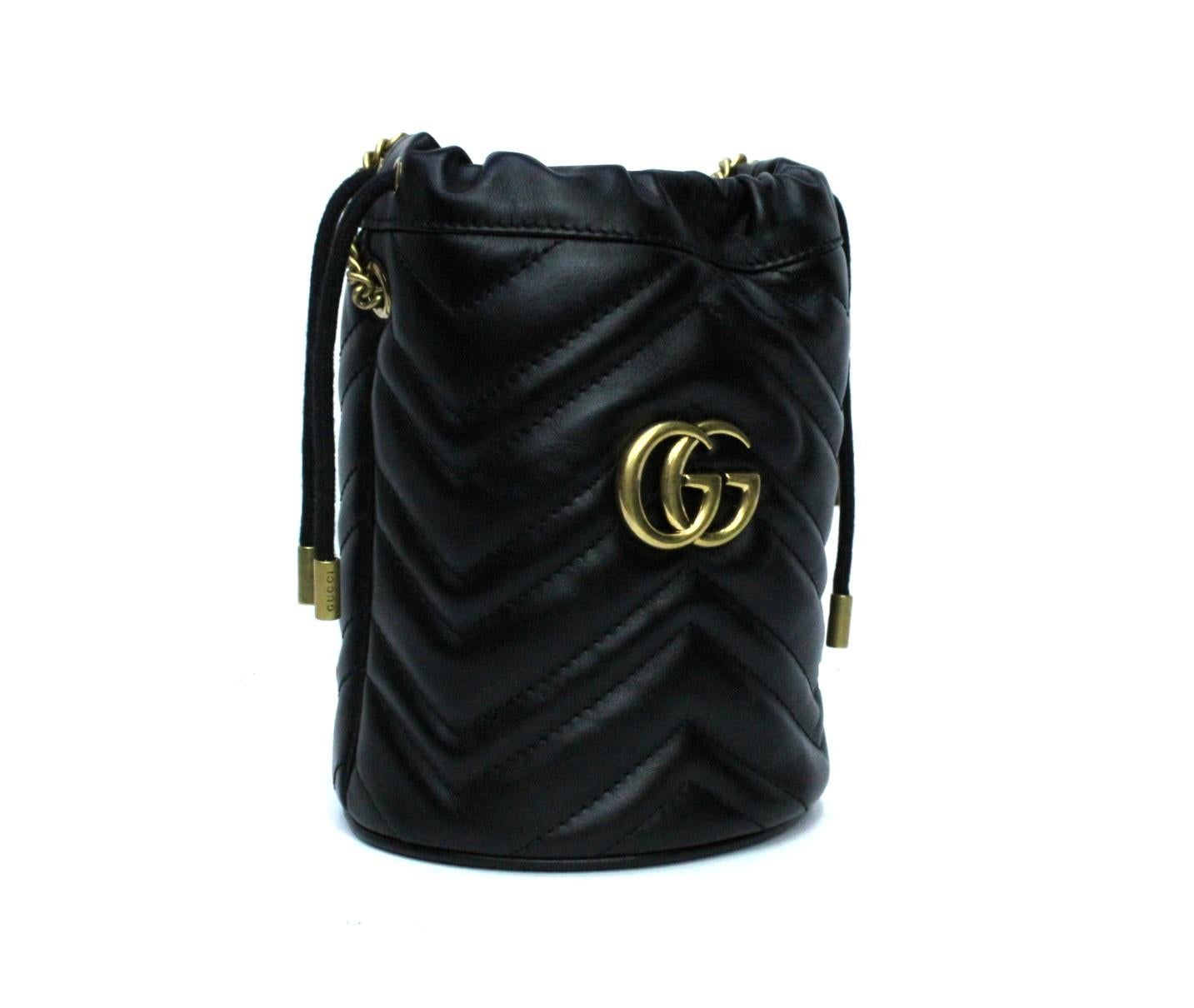 Gucci marmont mini bag in bucket made of black matelassé leather with Chevron pattern. Versatile and comfortable, it has a drawstring closure, a long chain so as to wear it on the shoulder or shoulder strap. Antique gold hardware. Very good
