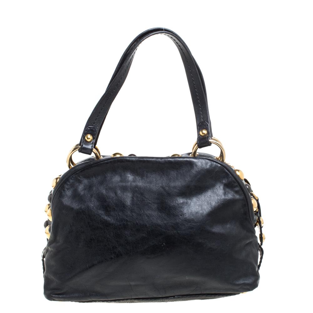 Diese aus Leder gefertigte Gucci-Tasche hat zwei Henkel und ein geräumiges Innenfach aus Stoff. Die Außenseite ist mit goldfarbenen Herzmedaillons und Nieten verziert und mit schützenden Metallfüßen ausgestattet. Stellen Sie diese Schönheit zur