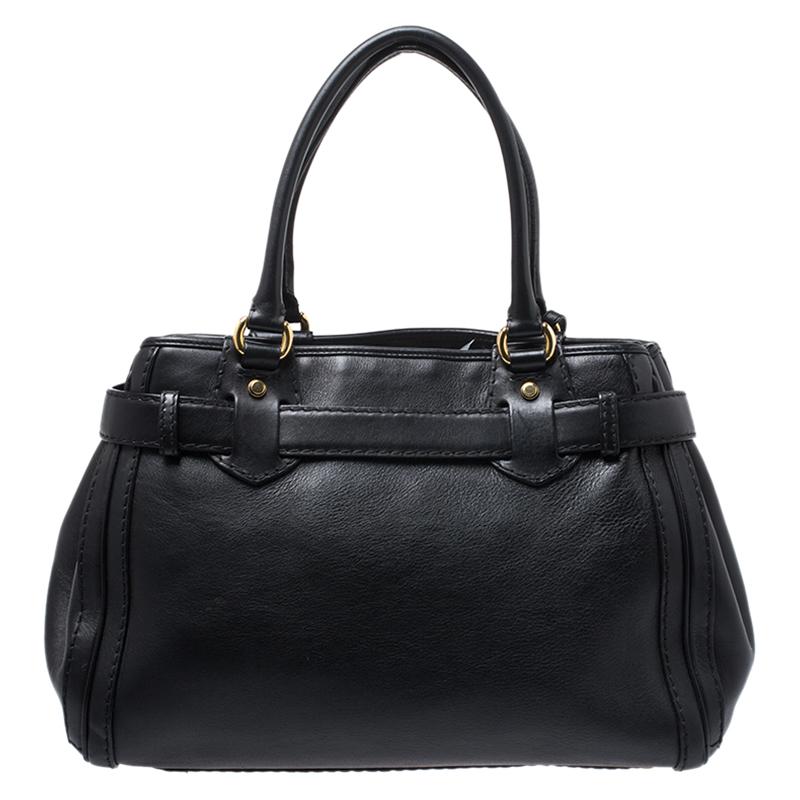 Add a touch of class to your everyday outfits with this Gucci Running tote. It features a black leather exterior and is equipped with rolled top handles and a dangling tag on the front. The gold-tone GG logo buckle on the front highlights the entire