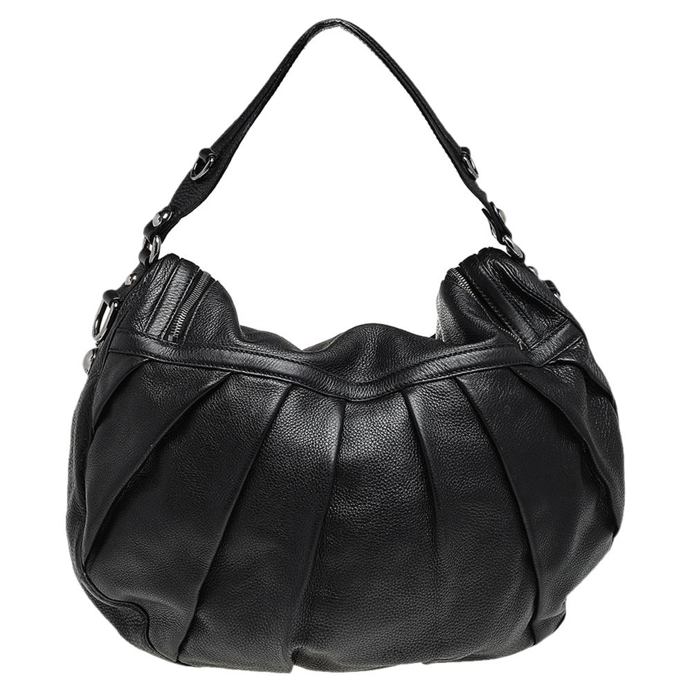 Another fine example of Gucci's regard for craftsmanship and style is seen in this hobo! It is made of leather and detailed with a Bit accent as one of the zipper pulls! It is held by a top handle and a shoulder strap for versatile carrying