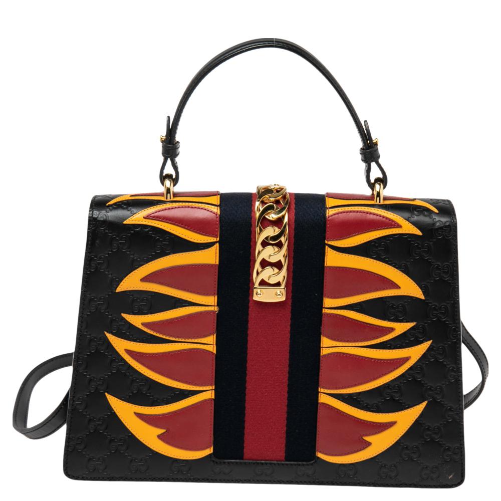 From the house of Gucci comes this gorgeous Sylvie bag that will perfectly complement all your outfits. It has been luxuriously crafted from Guccissima leather and styled with flame panels, a chain-Web decorated flap, and a buckle lock to secure the