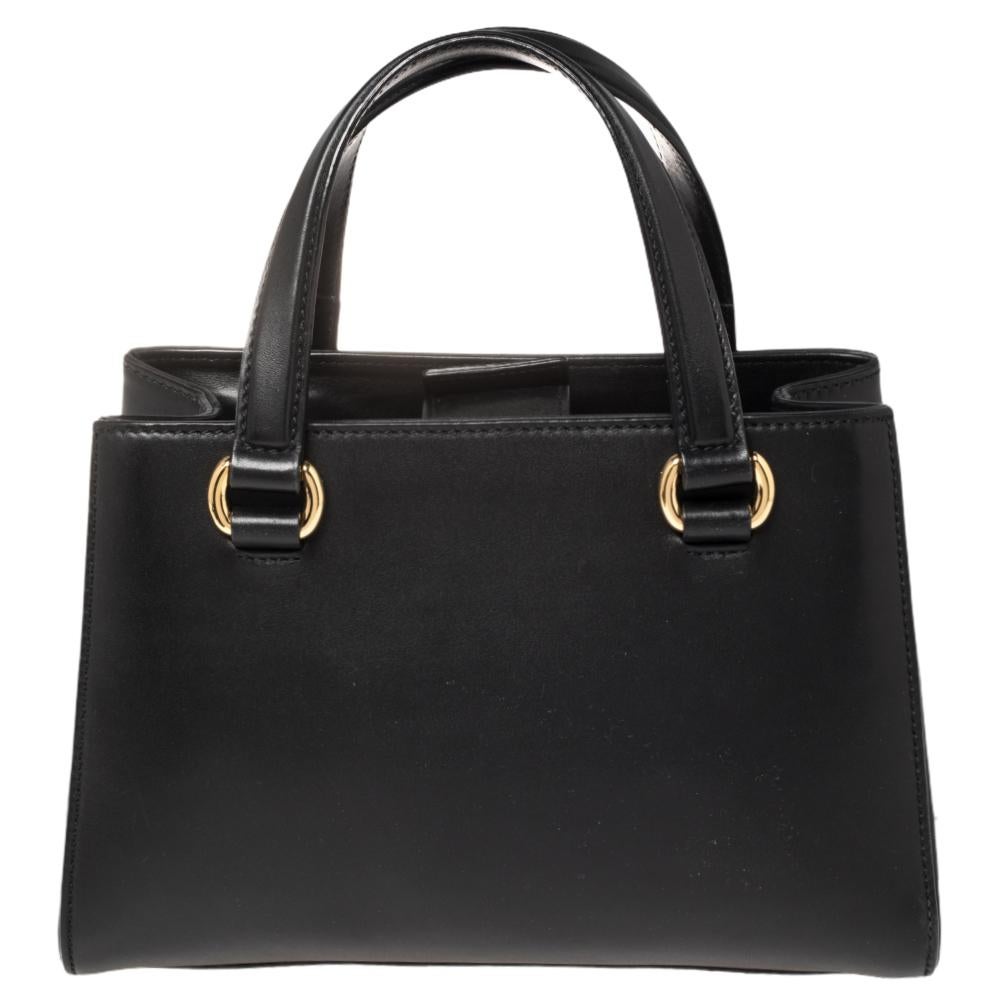 From the house of Gucci comes this gorgeous Sylvie tote that will perfectly complement all your outfits. It has been luxuriously crafted from black leather and equipped with a chain-web decorated front and an Alcantara interior. The bag is high on