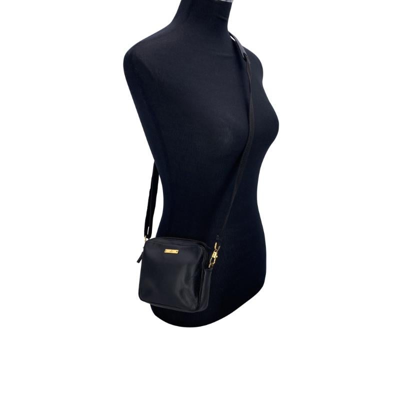 Questa Mini Crossbody Bag di Gucci è realizzata in elegante pelle nera e presenta una linguetta dorata 