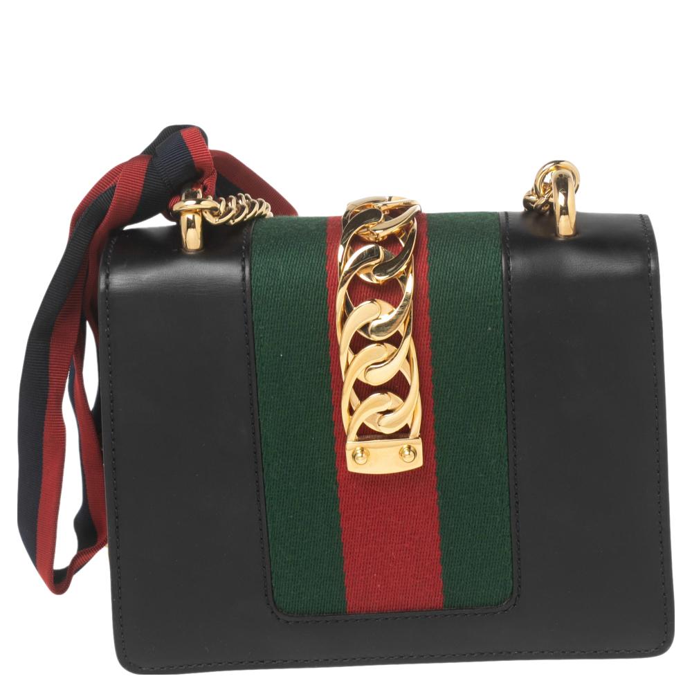 Gucci's Sylvie bag brings House codes and high-grade materials with a contemporary design. This mini Sylvie is crafted using black leather and styled with a chain-Web decorated flap and a buckle lock to secure the Alcantara interior. The bag is