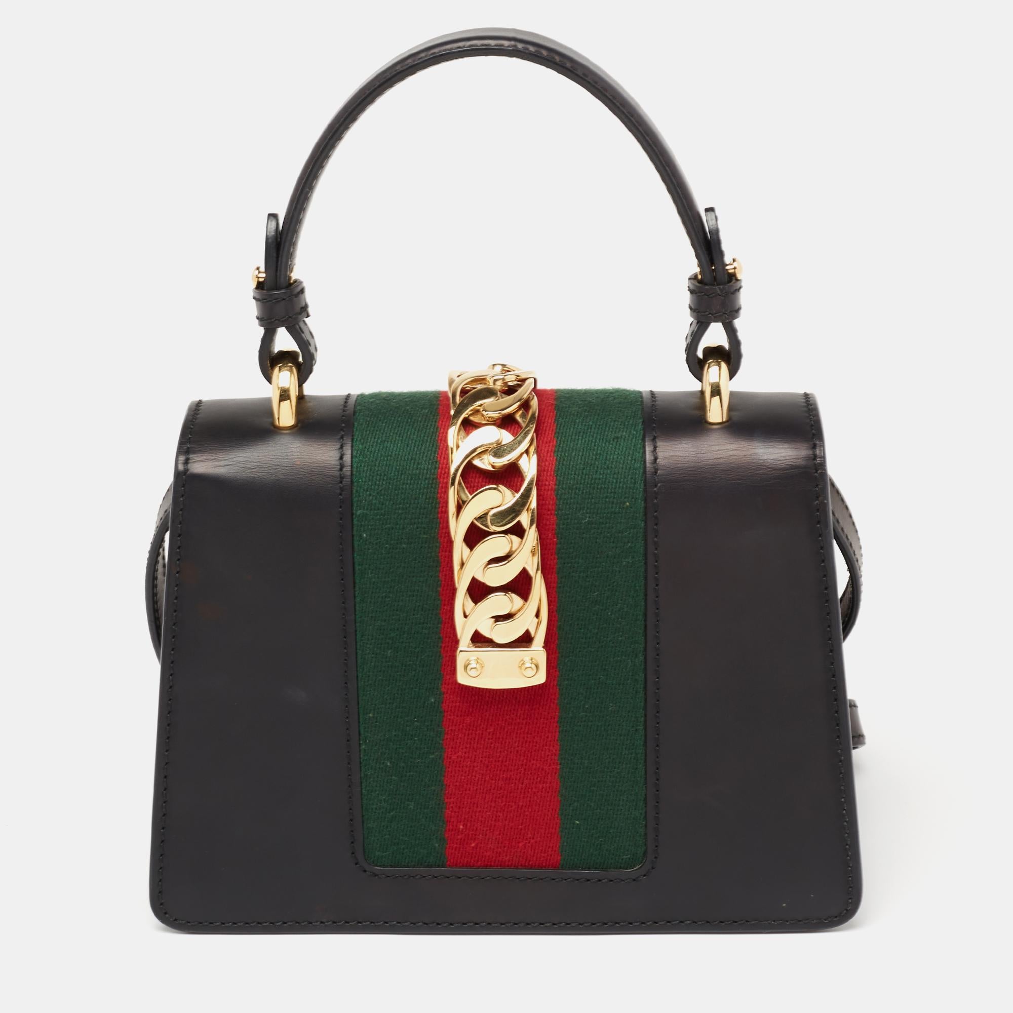 Gucci's Sylvie bag brings House codes and high-grade materials with a contemporary design. This Mini Sylvie is crafted using black leather and styled with a chain-Web decorated flap and a buckle lock to secure the Alcantara interior. The bag is