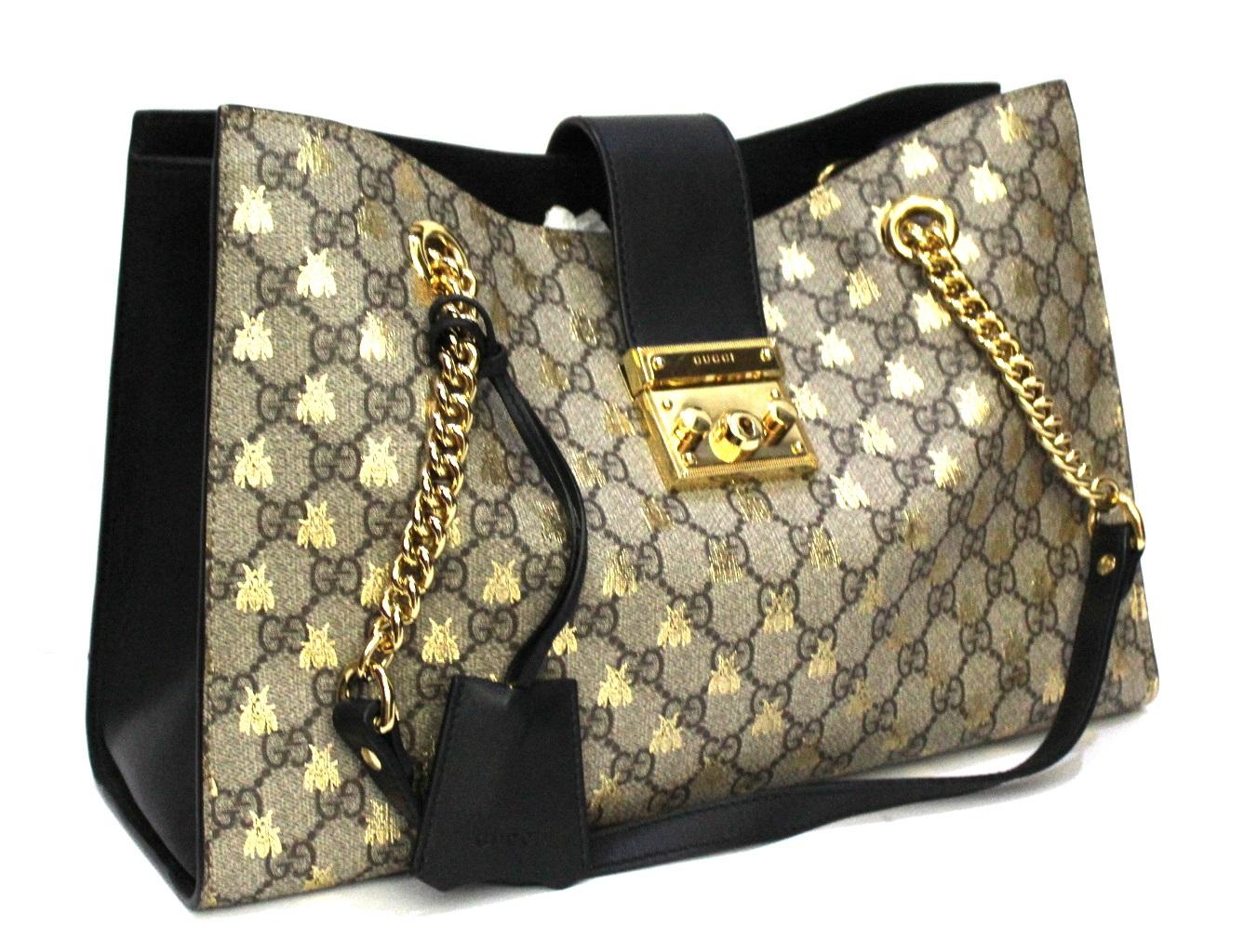 Gucci-Tasche mit Vorhängeschloss aus GG Supreme Canvas und schwarzem Leder mit goldener Hardware. 
Ausgestattet mit doppeltem Ledergriff und Kette. Hakenverschluss:: sehr großer Innenraum. 
Die Tasche ist in ausgezeichnetem Zustand.