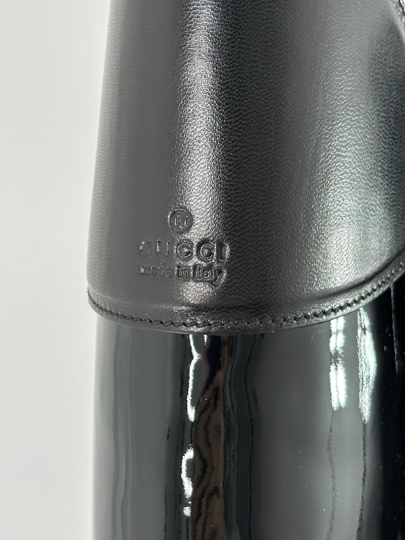 Gucci Black leather & black patent leather knee high boots with spike heels. The boots are curved up at the knee front so they are a bit above you knee and at the knee bend in the back. There are leather straps with silver buckles at each outside