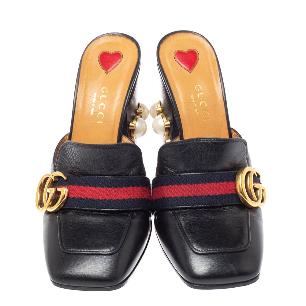 What a wonderful sight! These Gucci mules just bring joy to one's eyes. They are made from leather and designed with the signature web straps carrying the GG logo and block heels embellished with studs and faux pearls. The pair is beautiful and