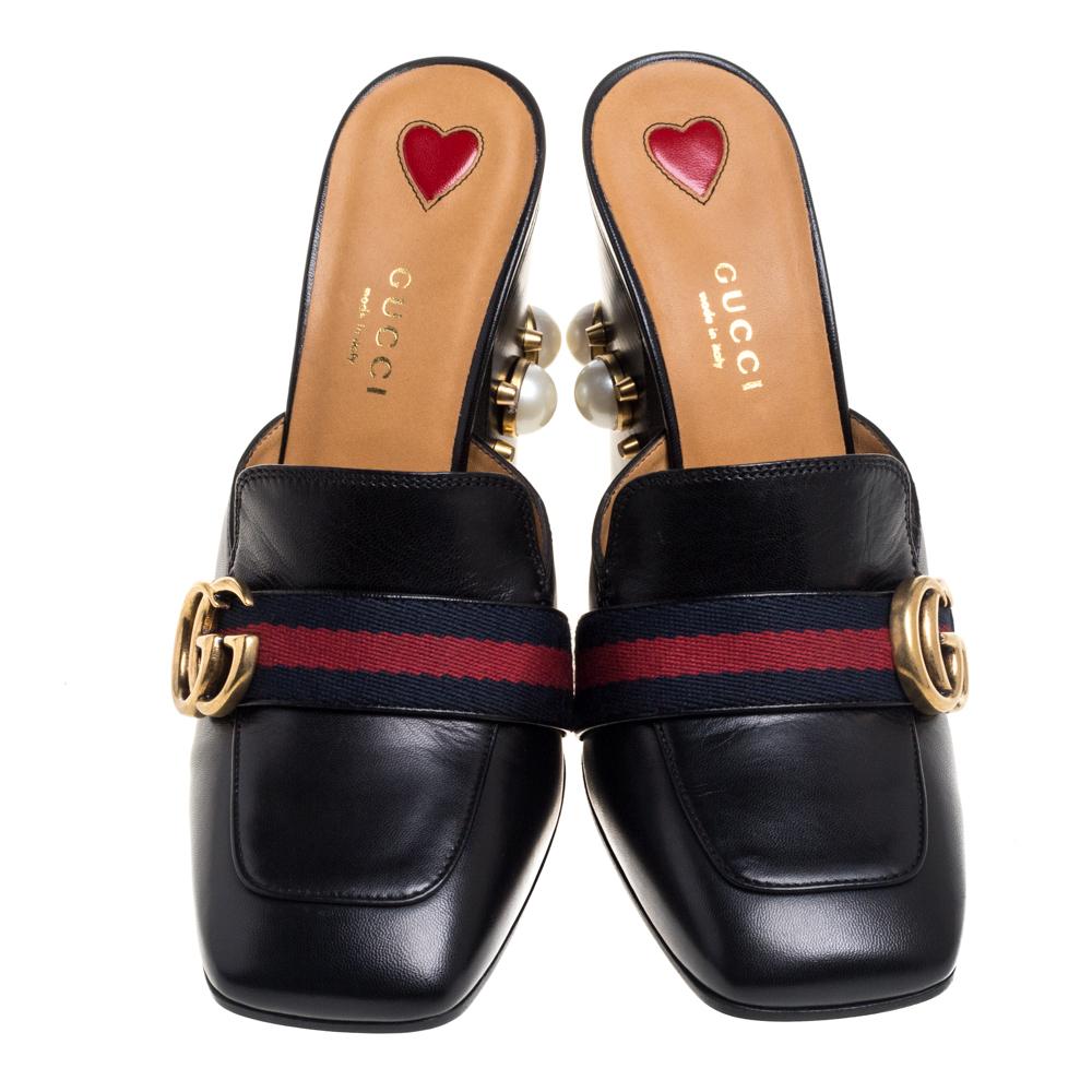 What a wonderful sight! These Gucci mules just bring joy to one's eyes. They are made from leather and designed with the signature web straps carrying the GG logo and block heels embellished with studs and faux pearls. The pair is beautiful and
