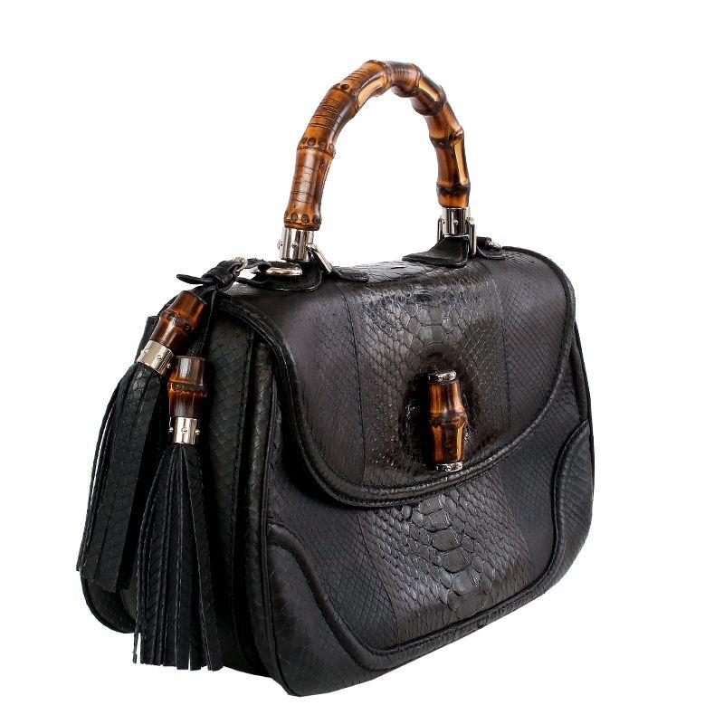 Gucci 'The New Bamboo' handbag in black python with bamboo turn-lock and bamboo handle. Has a detachable shoulder strap divided in a regular strap and a woven strap with silver-tone chain. Features two decorative tassels with bamboo finish. Inside