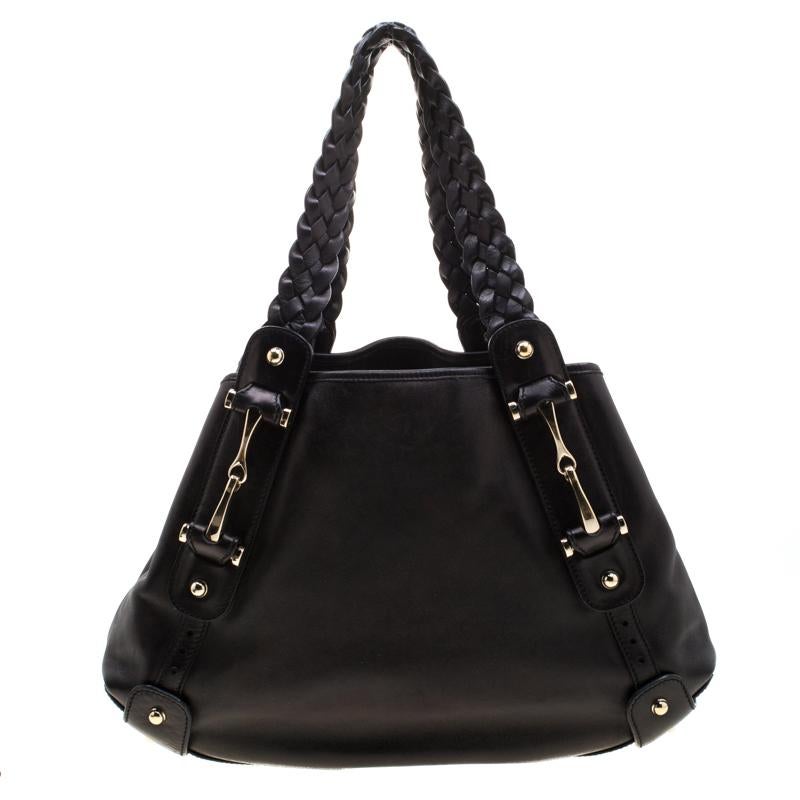 Take your style a notch higher with this Pelham hobo from Gucci. Cut out from leather, the bag features horsebit details, two braided leather handles, a spacious fabric interior and protective metal feet. This black hobo is perfect for daily