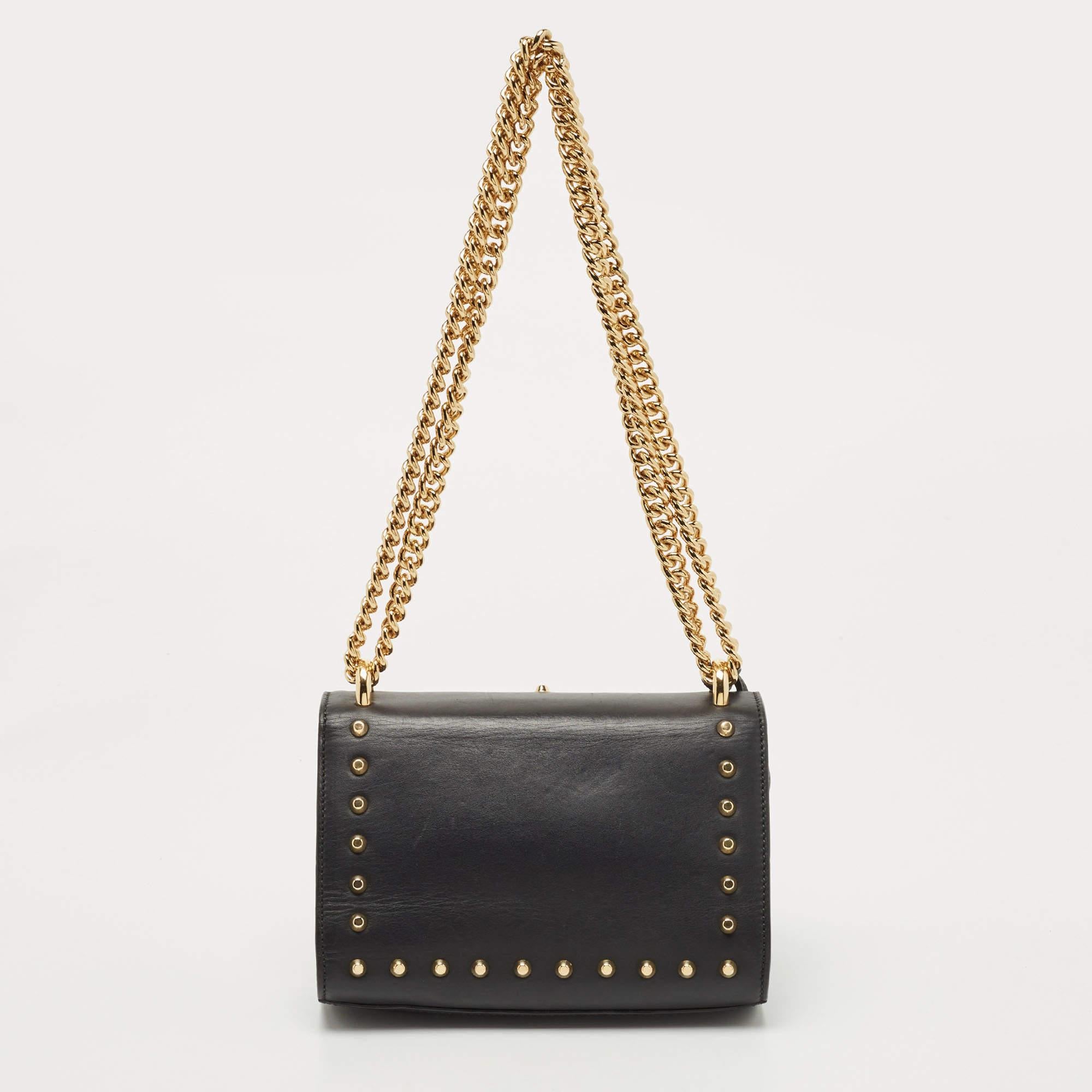 This Gucci creation has been skillfully crafted from leather and styled with embellishments and a flap holding a signature lock. The insides are lined with suede and sized to hold your essentials dutifully. The bag is equipped with a chain link so