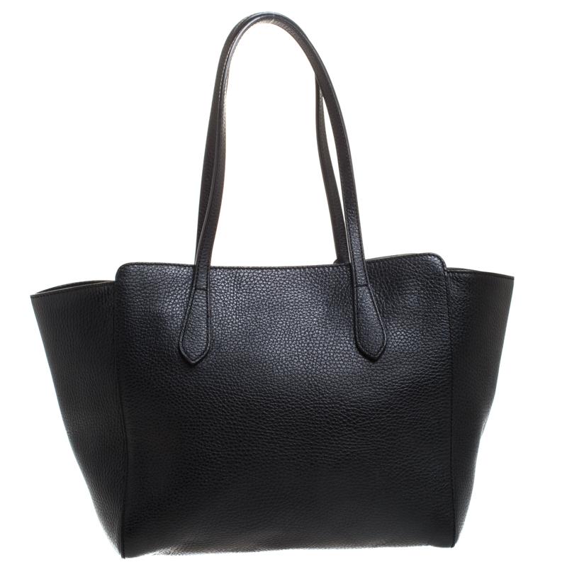 High on appeal and style, this tote is a Gucci creation. It has been crafted from leather in Italy and shaped to exude class and luxury. The bag comes with two handles, a spacious canvas interior, and the brand label on the front. This tote is ideal