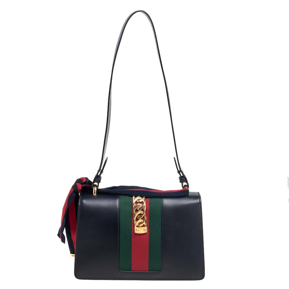 This gorgeous Gucci Sylvie bag will perfectly complement all your outfits. It has an elegant, structured silhouette highlighted by a decorative trim on the flap. The interior is sized well and a shoulder handle is provided for easy
