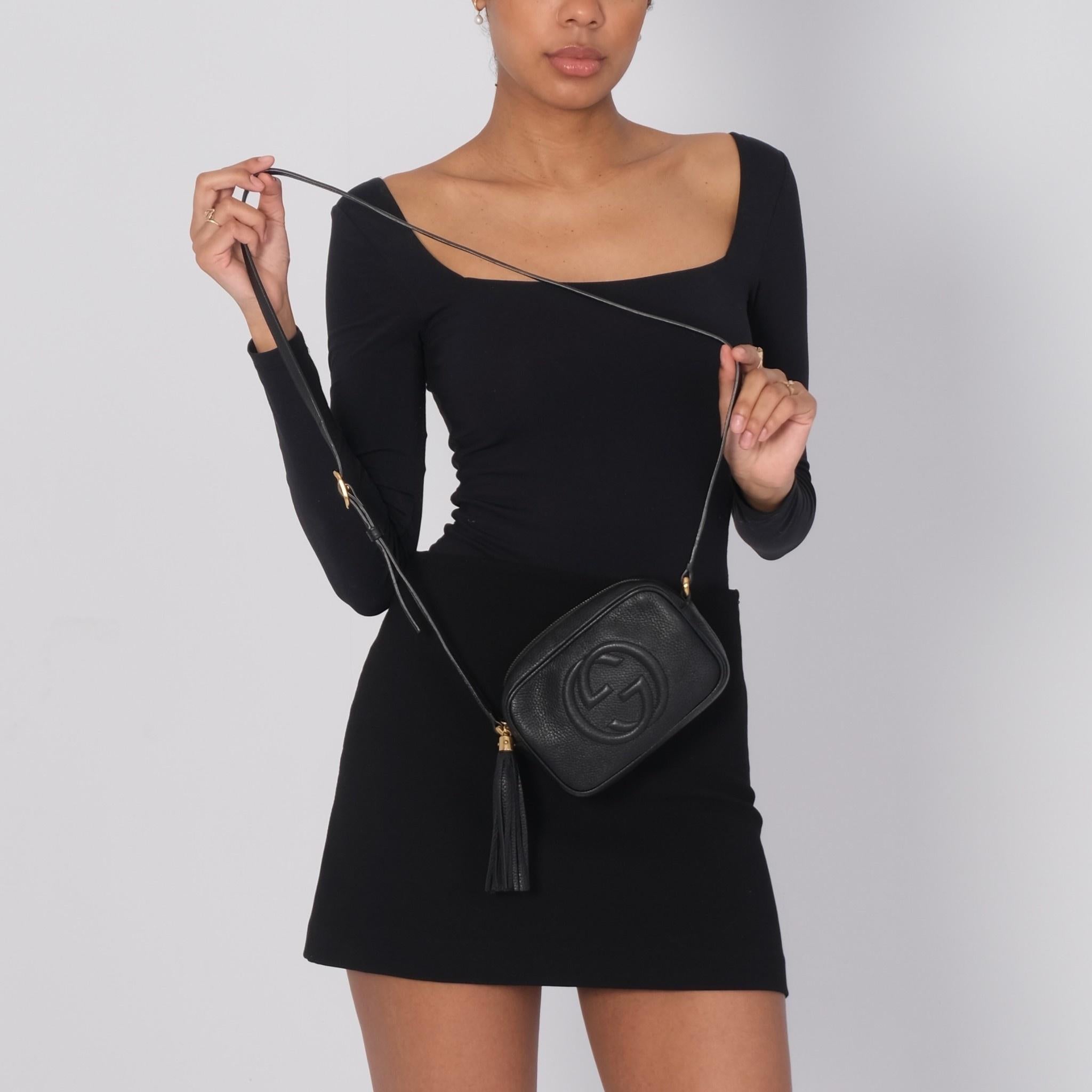 This camera shoulder bag is part of Gucci’s soho collection and is currently discontinued. The classic camera style bag features pebbled leather in black, top zip closure, gold tone hardware and a long strap that can be worn on the shoulder or