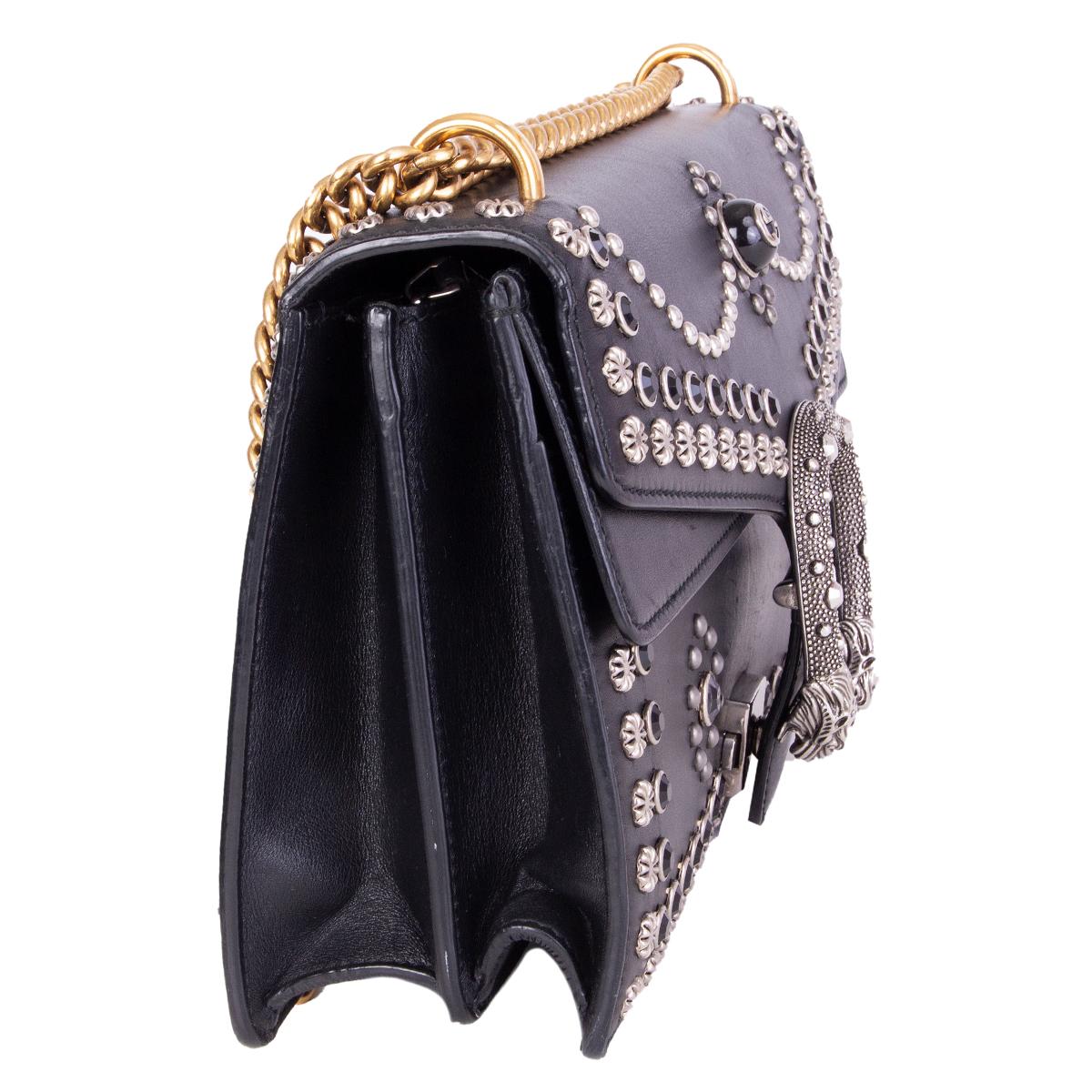 Gucci 'Small Studded Dionysus' shoulder bag crafted in black studded calfskin embellished with silver-tone studs and black crystals. Features a gold-tone chain link shoulder strap and textured tiger head push-pin closure. Lined in pale pink