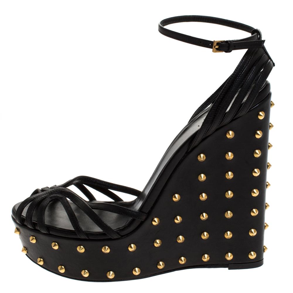 How gorgeous are these wedges from Gucci! They have been crafted from leather and feature an open toe silhouette. They flaunt a strappy design and come equipped with ankle fastening, comfortable insoles and wedge heels covered in studs. They'll look