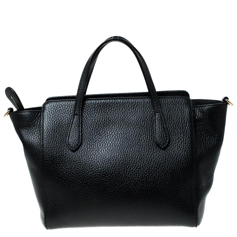 Gucci is known for delivering classy and elegant designs. This Swing tote from the brand is made from black leather. The bag features gold-tone hardware, and dual flat handles. The top zip closure opens to a canvas-lined interior with slip pockets