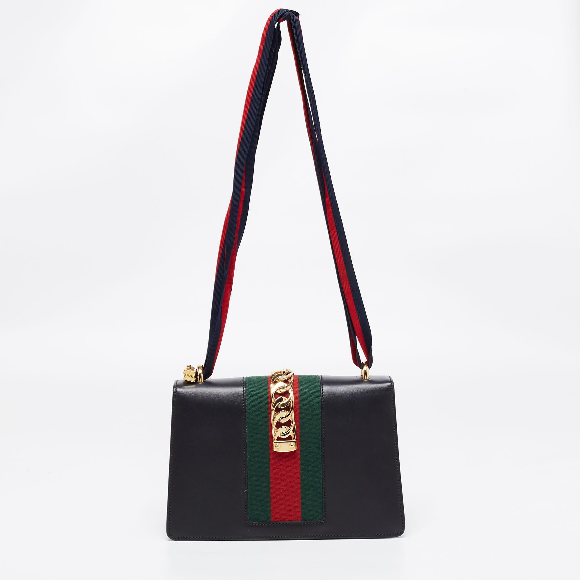 All the designs from Gucci, like this Sylvie bag, reflect a sense of innovation and tradition. Crafted from leather, it is admired for its alluring finish and structured silhouette. The handle at the top makes it practical, and the signature