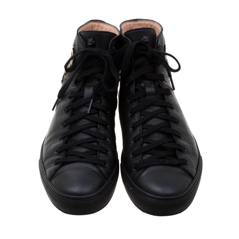 This pair of black Gucci sneakers are crafted from leather featuring colorful tiger patch on the quarters and signature web detail on the counters. They come with lace-up vamps and leather-lined insoles for added comfort. Style them with jeans and a