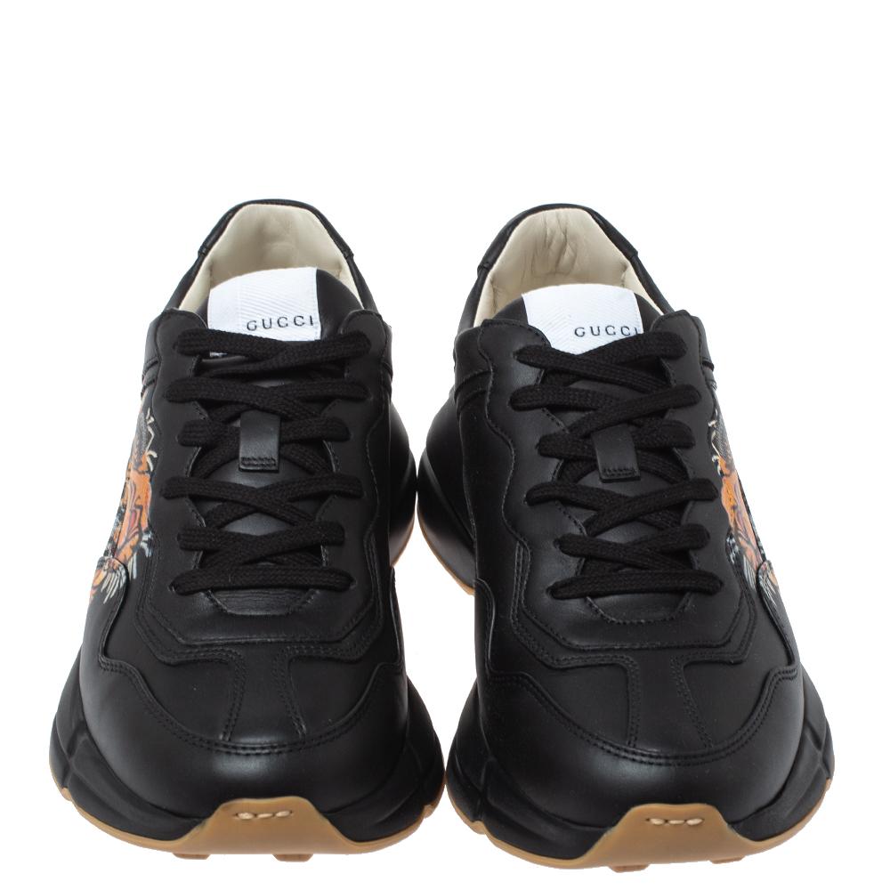 The time to feel trendy is now as Gucci brings you these superhit sneakers in black. They are crafted from leather, detailed with lace-ups, and a colorful tiger print on the sides and are set on highly comfortable soles. You are sure to receive nods