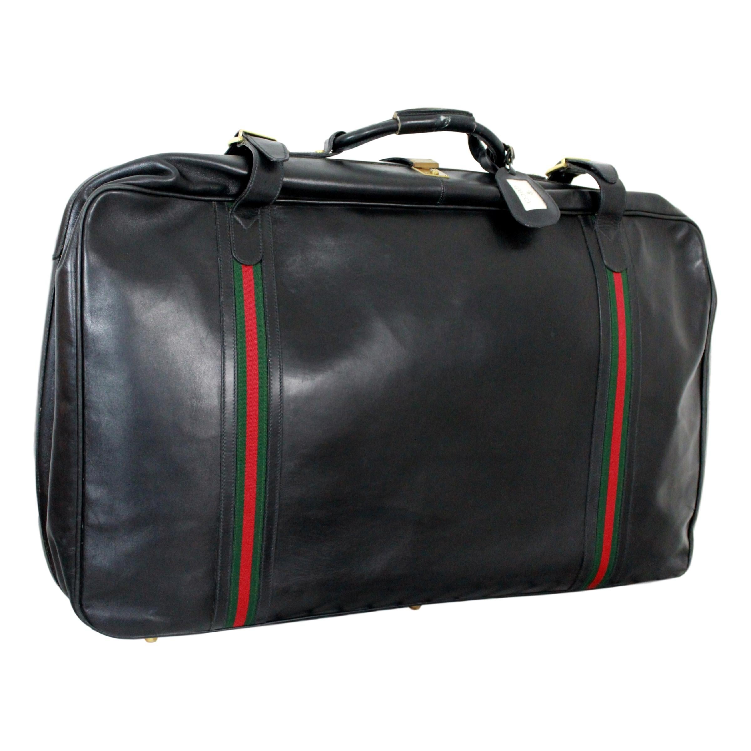Gucci vintage 70s luggage set. Black leather with two green and red stripes. Monogrammed beige canvas interior with leather straps and pockets. Fully functional double zips and buttons. Details in gold metal. Original Gucci cardboard tag by name on