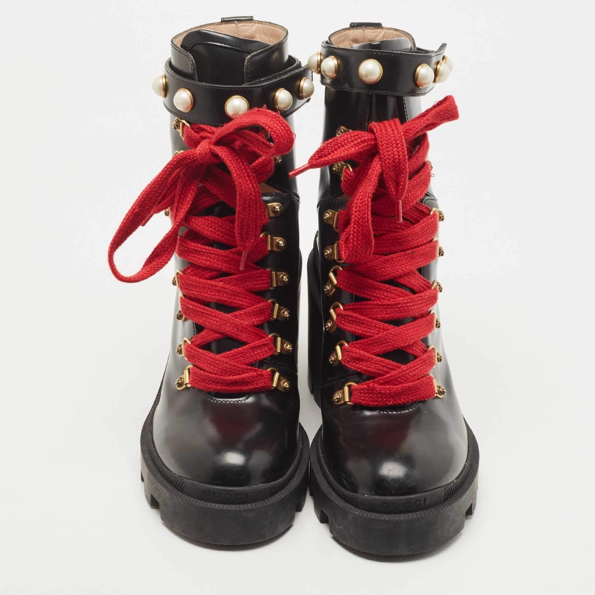 These Gucci ankle-length boots are a perfect amalgamation of comfort, style, and class! The black leather construction takes the form of a rounded-toe silhouette that is enhanced with red laces and gold-tone metal hooks on the vamps, faux
