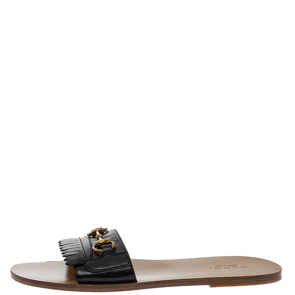 These pretty slides sandals are just the ideal choice for a relaxed day out. The flats are crafted from black leather and accented with fringe details and the signature Horsebit motif in gold-tone metal on the front strap. They are complete with