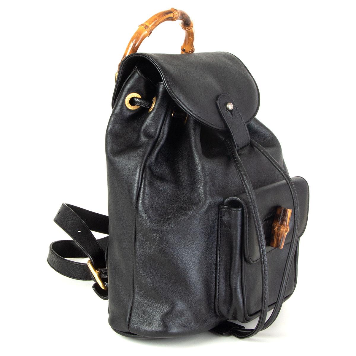 Gucci vintage backpack in black calfskin with gold-tone hardware, bamboo top handle, dual adjustable flat shoulder straps, one exterior cargo pocket with bamboo turn-lock closures. Lined in black canvas with one zipper pocket against the back.