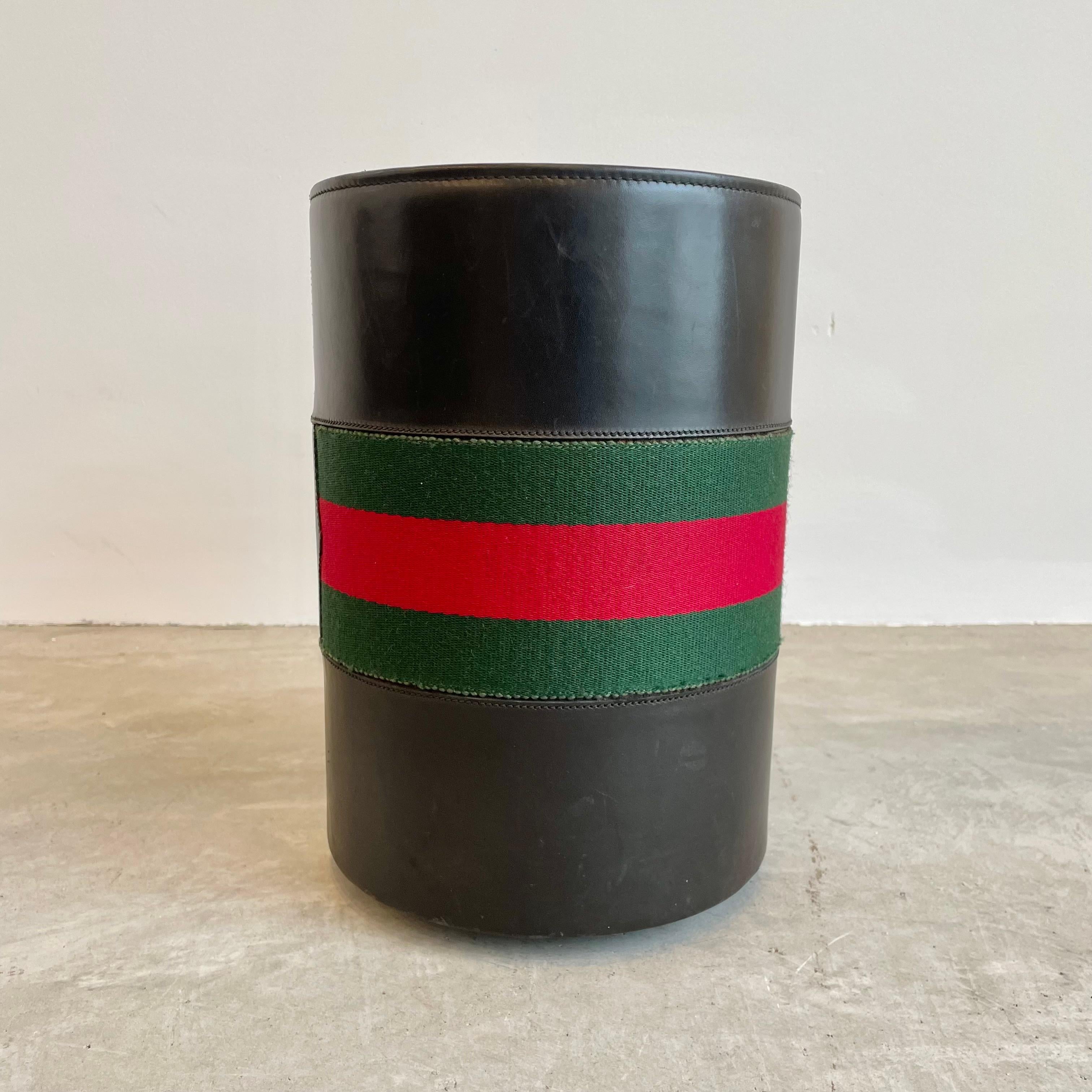 Vintage Gucci black leather waste paper basket, circa 1970s. Signature red and green fabric stripes along the middle. Stands atop four gold cone-shaped feet. Marked ‘Made in Italy by Gucci’ on the base. Gorgeous addition to any office.