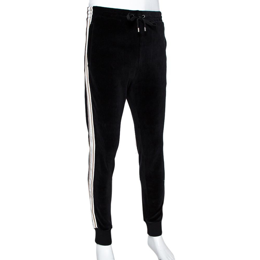Lounge around in comfort and style with these amazing track pants from Gucci. Black in color, they have a durable body rendered in a cotton blend and feature the brand label on one leg, an elasticised waistline, and two pockets.

Includes:Original