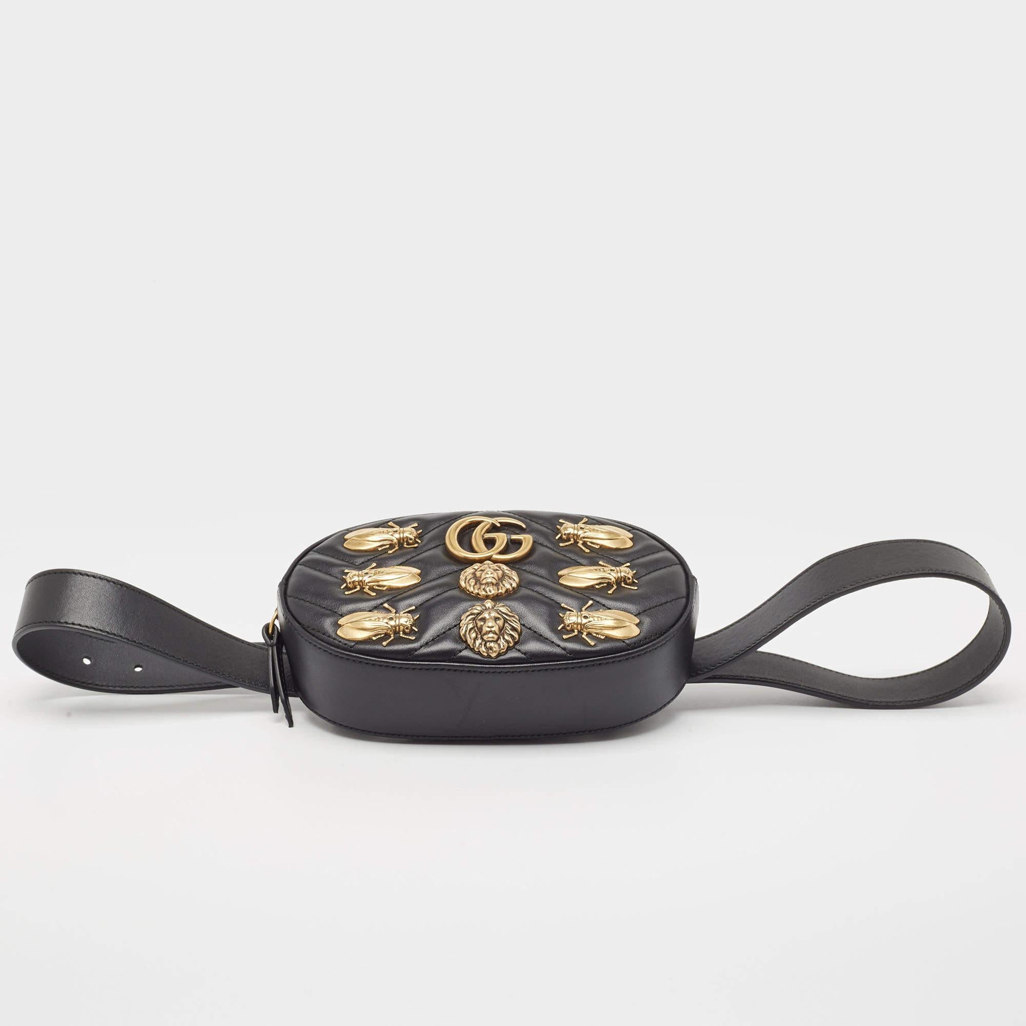 This Gucci bag here is crafted in matelassé leather and is equipped with a zipper fastening that opens to a well-sized Alcantara interior. On the front, there is a GG logo amidst animal studs, and an adjustable belt is provided for you to wear