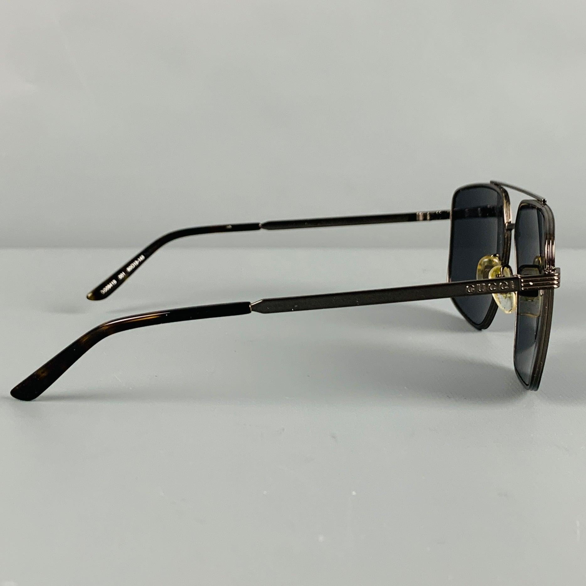GUCCI-Sonnenbrille
in einem schwarzen
Metall mit quadratischem Pilotenstil und getönten Gläsern. Wird mit rotem Samtetui geliefert. Made in Italy Ausgezeichneter Pre-Owned Zustand. 

Markiert:   GG0941S 001 60 15-145 

Abmessungen: 
  Rahmenbreite:
