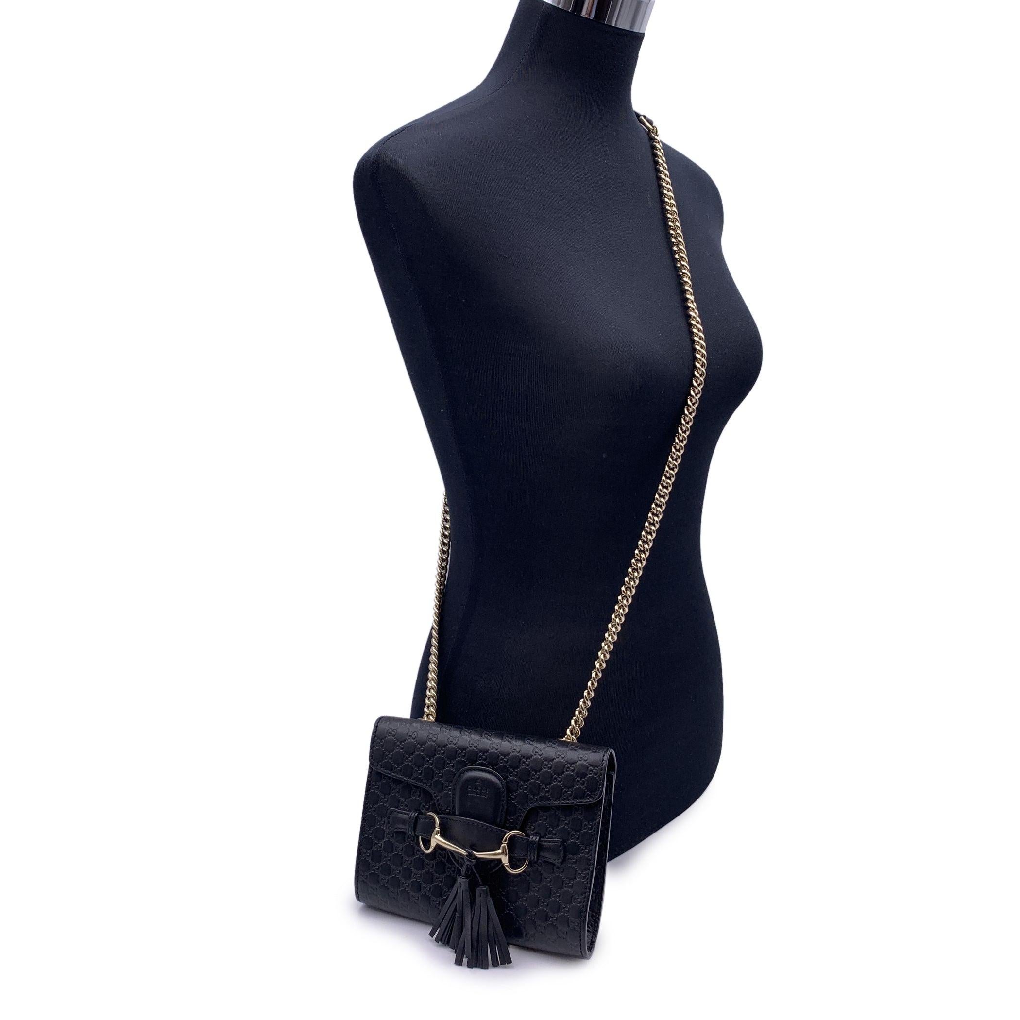 Black Microguccissima leather Gucci 'Emily' Chain shoulder bag. Light gold metal hardware. Chain-link shoulder strap. Horsebit & Tassels detail at front. Canvas interior lining. 1 slit pocket inside. Fold-in flap closure at front. 'GUCCI - Made in