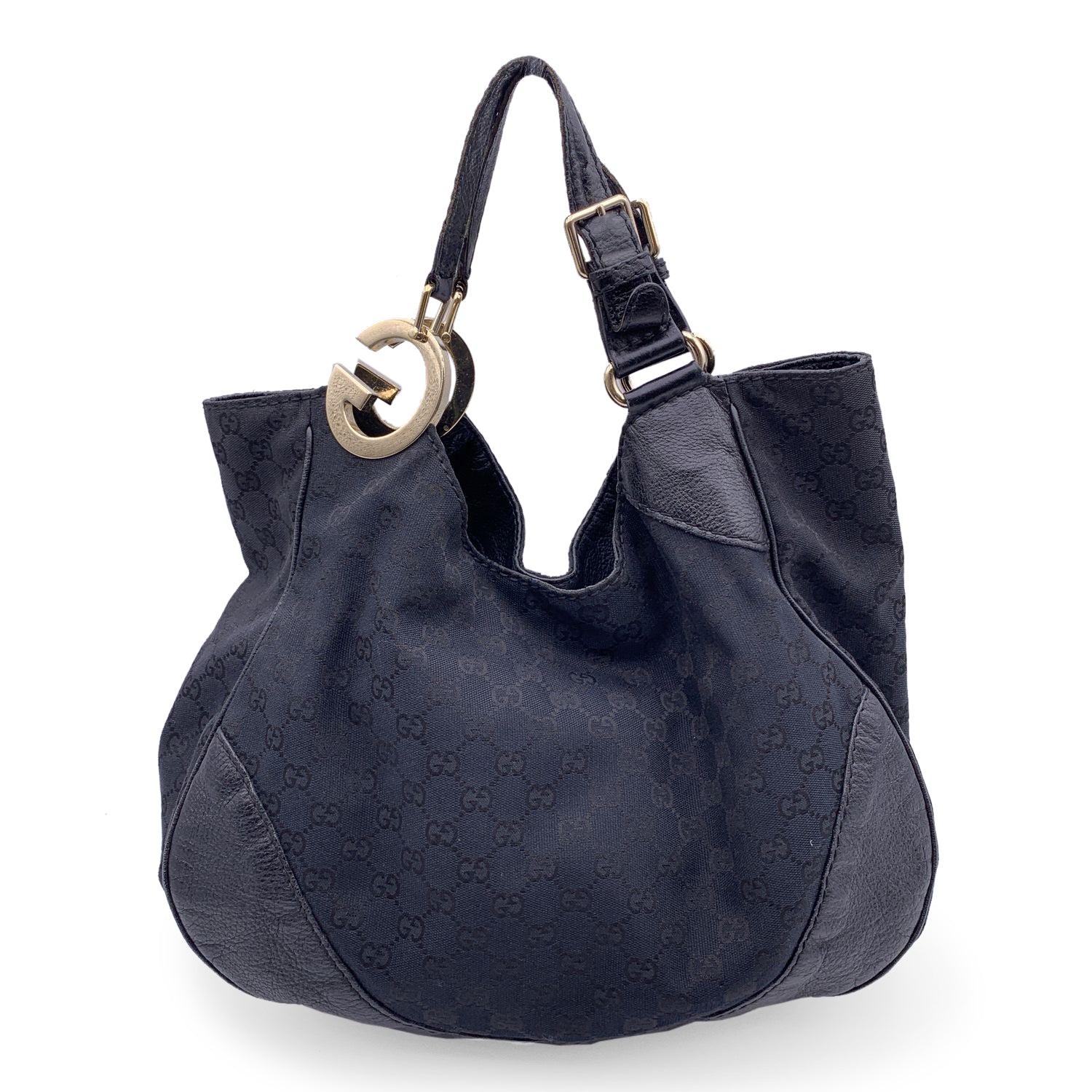 Gucci black monogram canvas Charlotte bag . Black canvas tote bag with black leather trim and handles. Gold metal GG detailing on handles. Magnetic button closure on top. Black fabric lining. 1 side zip pocket inside. 'GUCCI - Made in Italy' tag