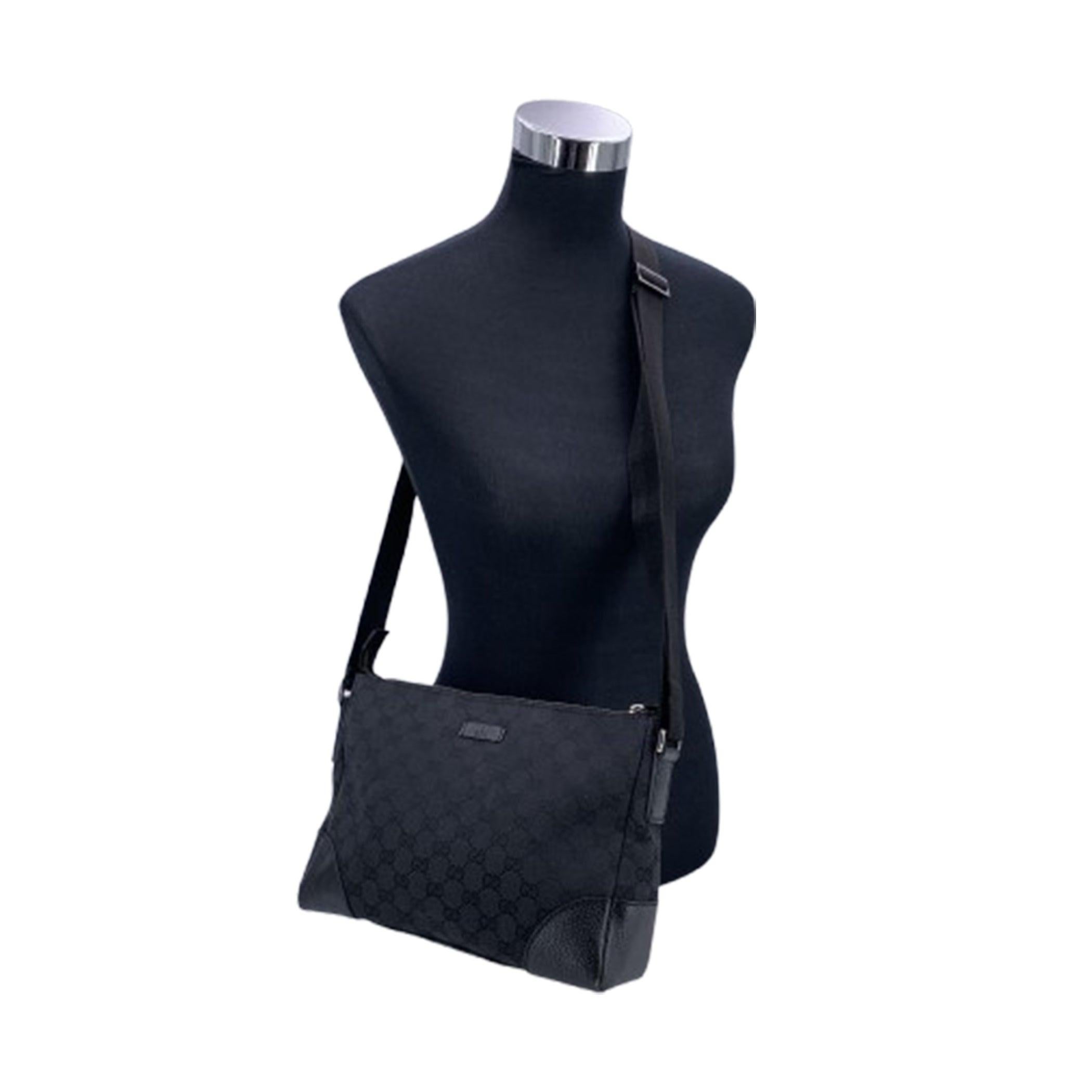 Rehaussez votre style quotidien avec le sac à bandoulière en toile Monogram de Gucci, une combinaison parfaite de praticité et de design luxueux. Fabriqué en toile noire résistante, ce sac messager est joliment rehaussé de garnitures en cuir noir,