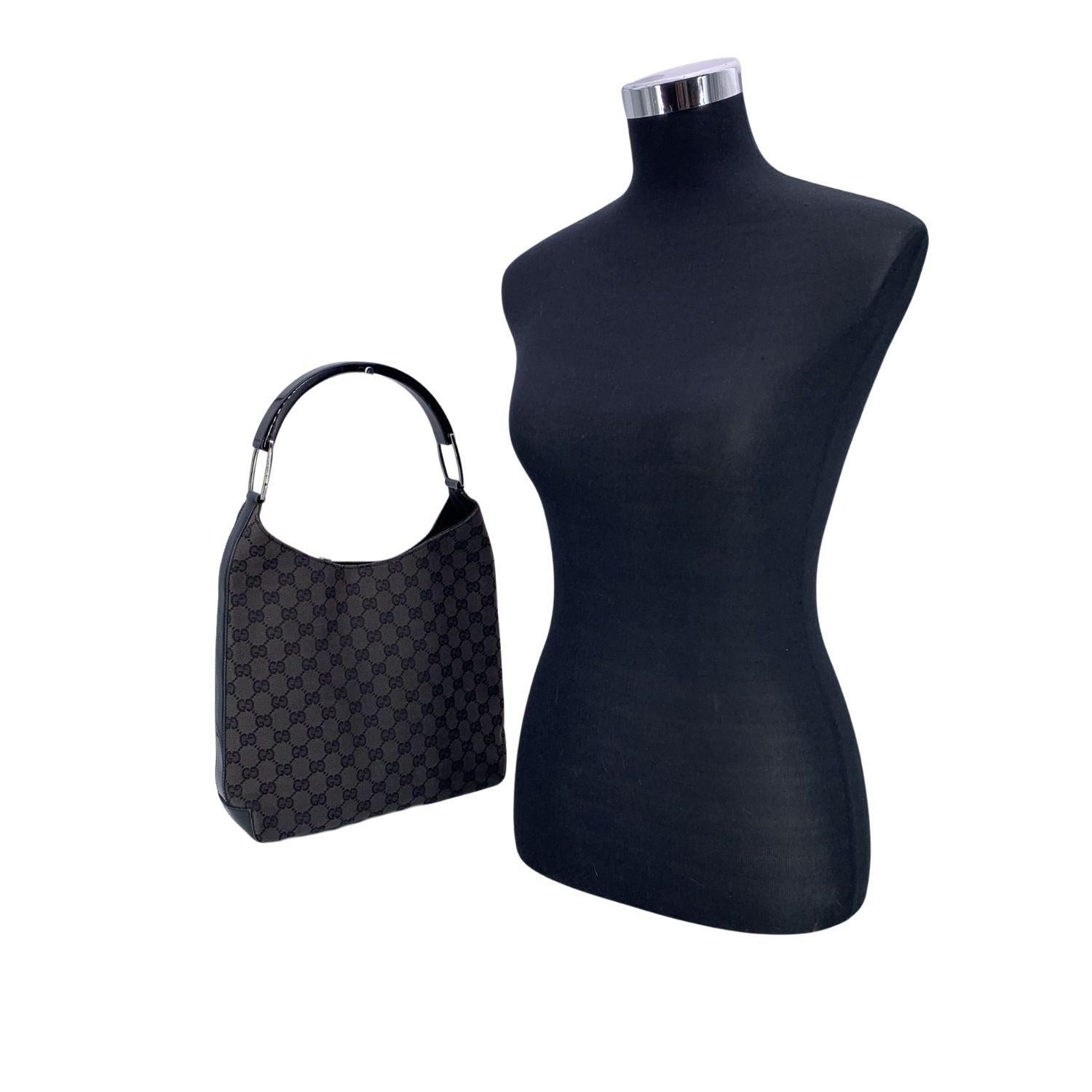 Step into timeless Italian elegance with this vintage Gucci black monogram canvas hobo shoulder bag - a quietly bold statement piece from an era when craftsmanship met edge. Its iconic GG monogram is set against deep black canvas, accented by sleek