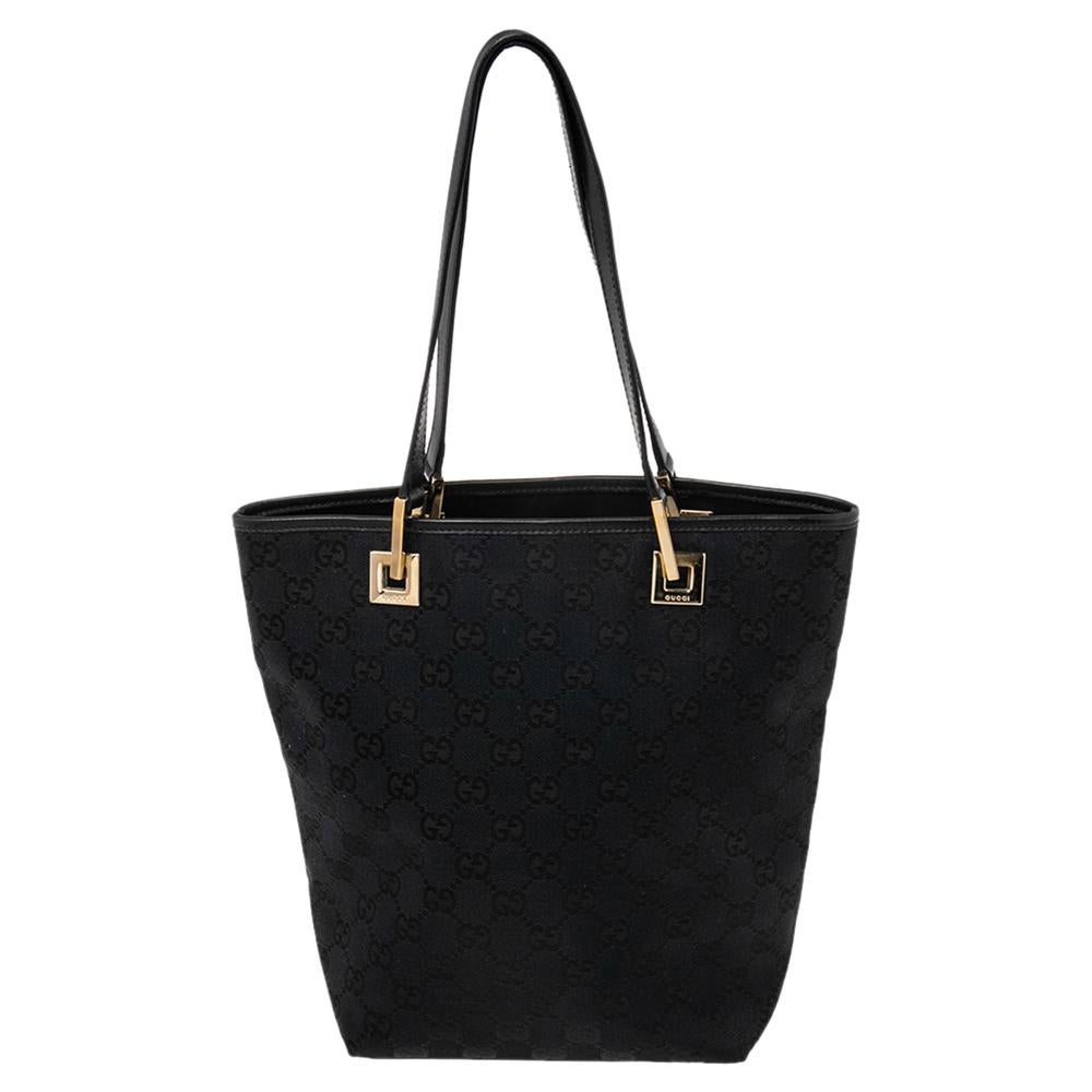 This bucket tote from Gucci is a versatile, chic creation that will prove highly functional to you. It is made using black Monogram canvas on the exterior with distinct gold-toned hardware used to complete its fittings. This precisely structured