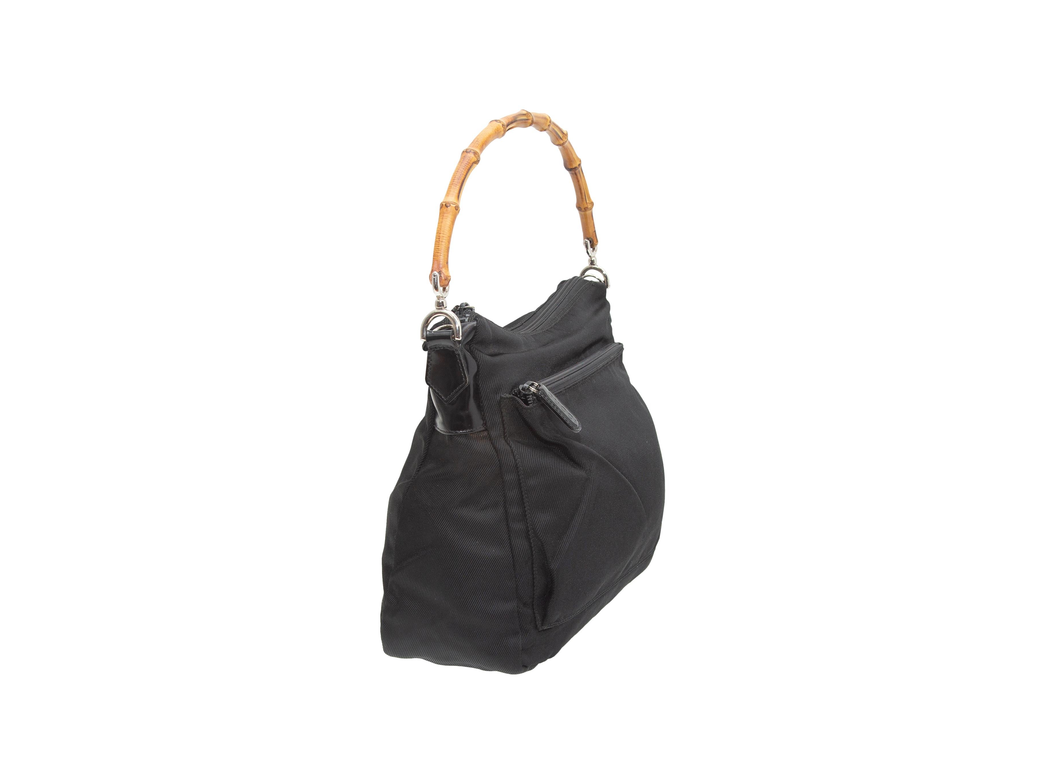 Product details: Vintage black nylon bag by Gucci. Bamboo top handle. Silver-tone hardware. Exterior front pocket. Optional shoulder strap. Zip closure at top. 11