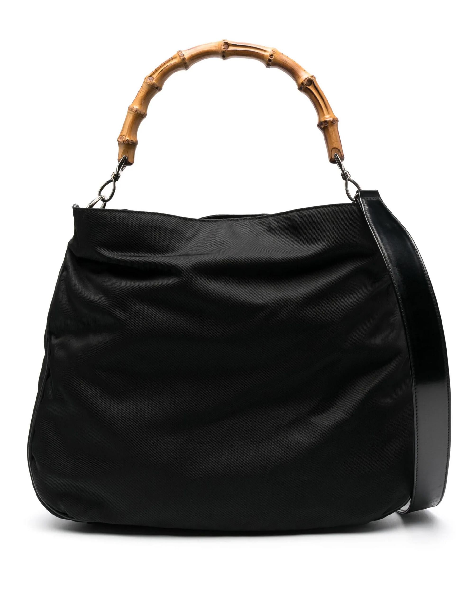 Sac à main Gucci en toile de nylon et cuir noir avec une bandoulière amovible (33,5in. (85cm) X 1,18in. (3cm) , des poignées en bambou, un fond en cuir, une ouverture à pression avec logo sur le dessus, des ferrures argentées, une doublure