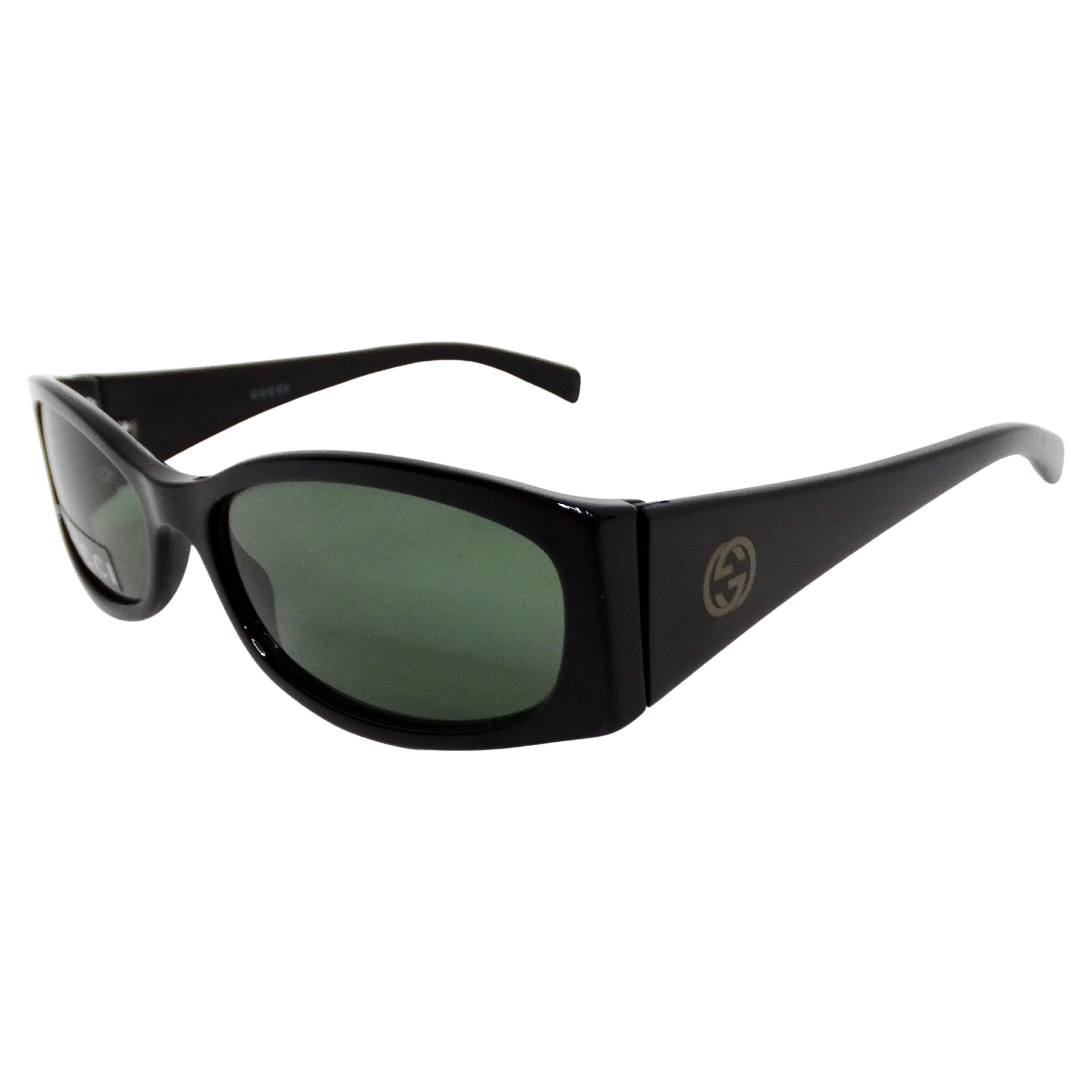 Gli occhiali da sole Gucci Black Oval Frame Green Tinted del 1999 circa sono un accessorio sofisticato e senza tempo che incarna la moda di lusso della fine del XX secolo. Realizzati con un'elegante montatura ovale nera, questi occhiali da sole