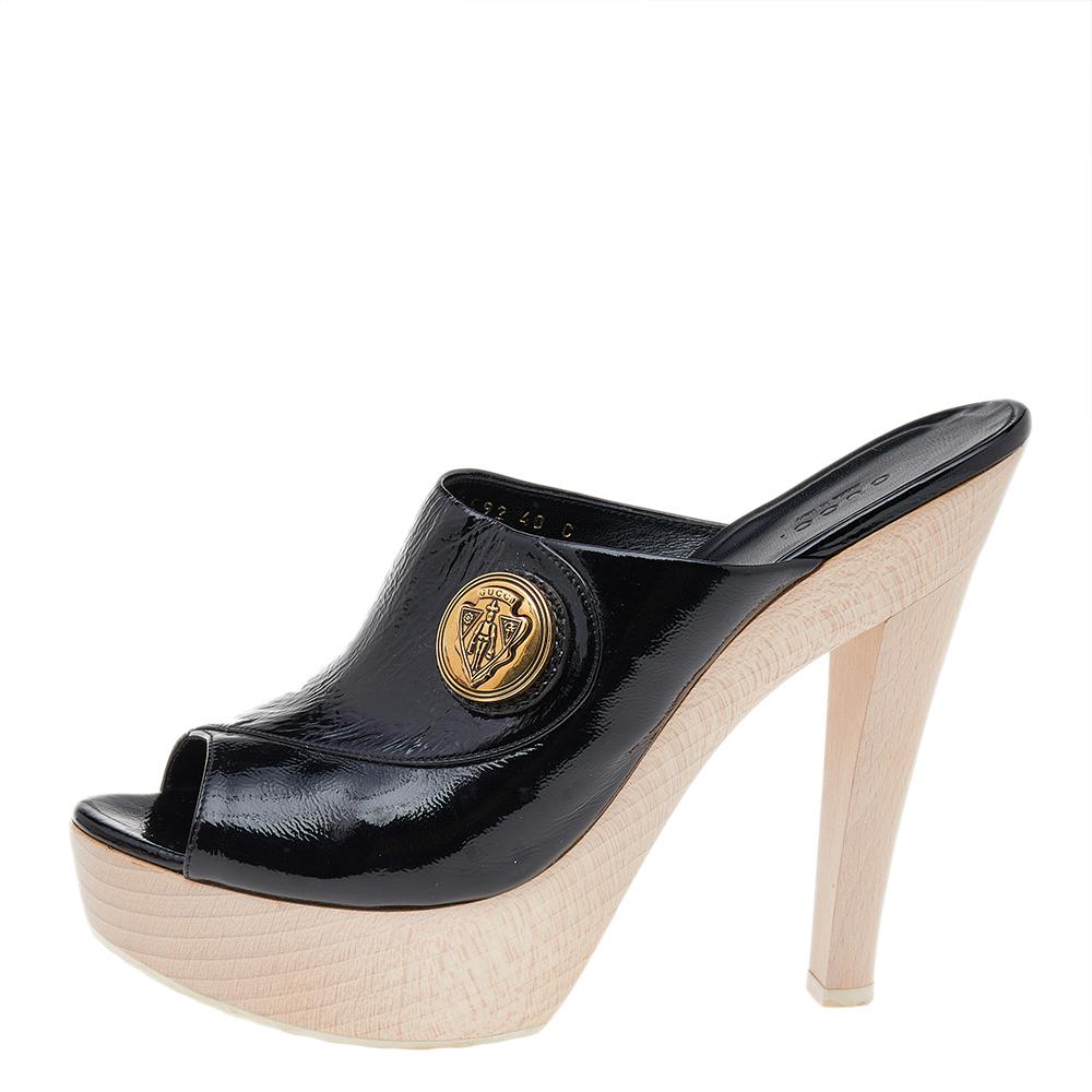 These Gucci clogs are comfortable and stylish. Crafted from glossy black patent leather, they feature gold-tone Gucci hardware, peep-toe and wooden 15 cm heels. These clogs are lined with black leather and have Gucci labeled insoles.
