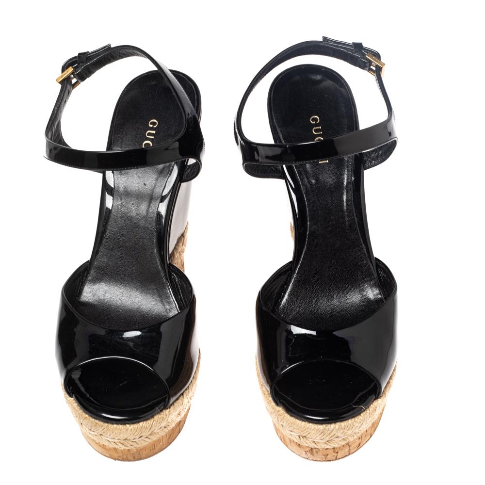 Step out feeling bold and confident as you wear these sandals from Gucci. They are crafted using black patent leather on the exterior and flaunt cork and espadrille wedge heels and gold-toned hardware. Take your style a few inches higher as you wear