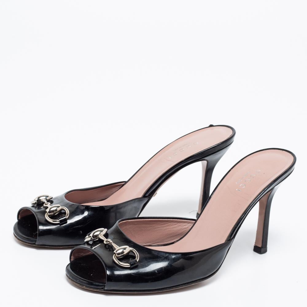 Feel glamorous when you slip into these Gucci black sandals. They are crafted from patent leather and are accented with silver-tone Horsebit detailing at the vamps. They come with smooth insoles and slender 9 cm heels.