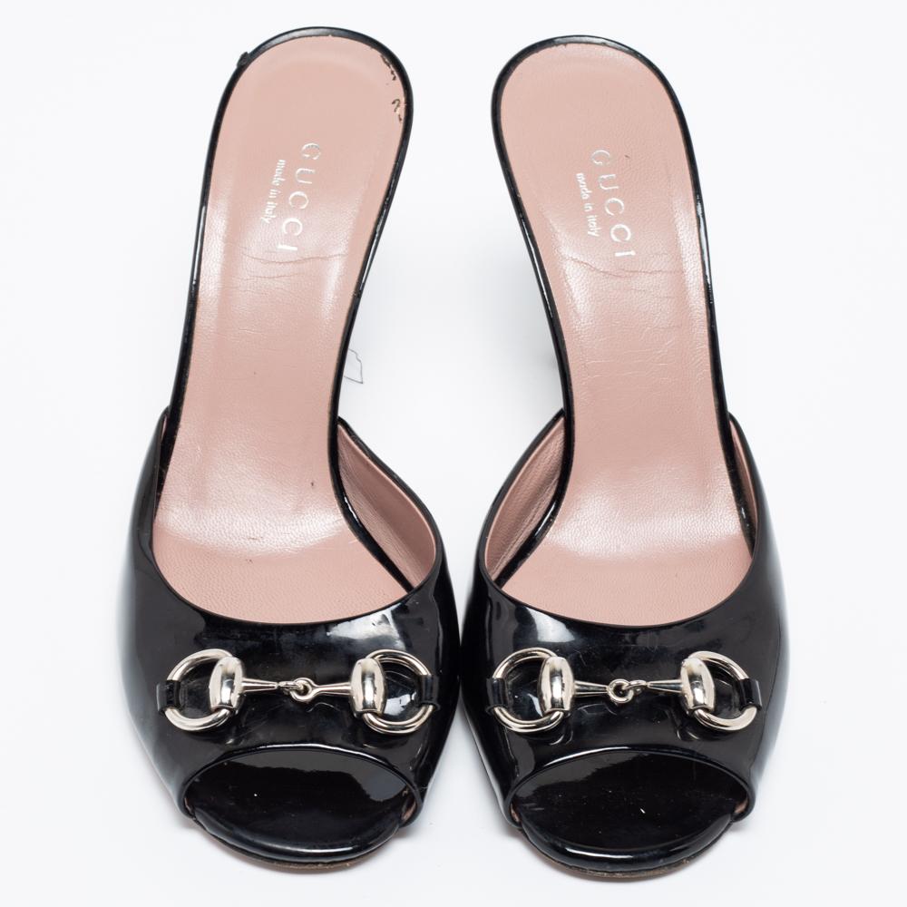 Feel glamorous when you slip into these Gucci black sandals. They are crafted from patent leather and are accented with silver-tone Horsebit detailing at the vamps. They come with smooth insoles and slender 9 cm heels.

