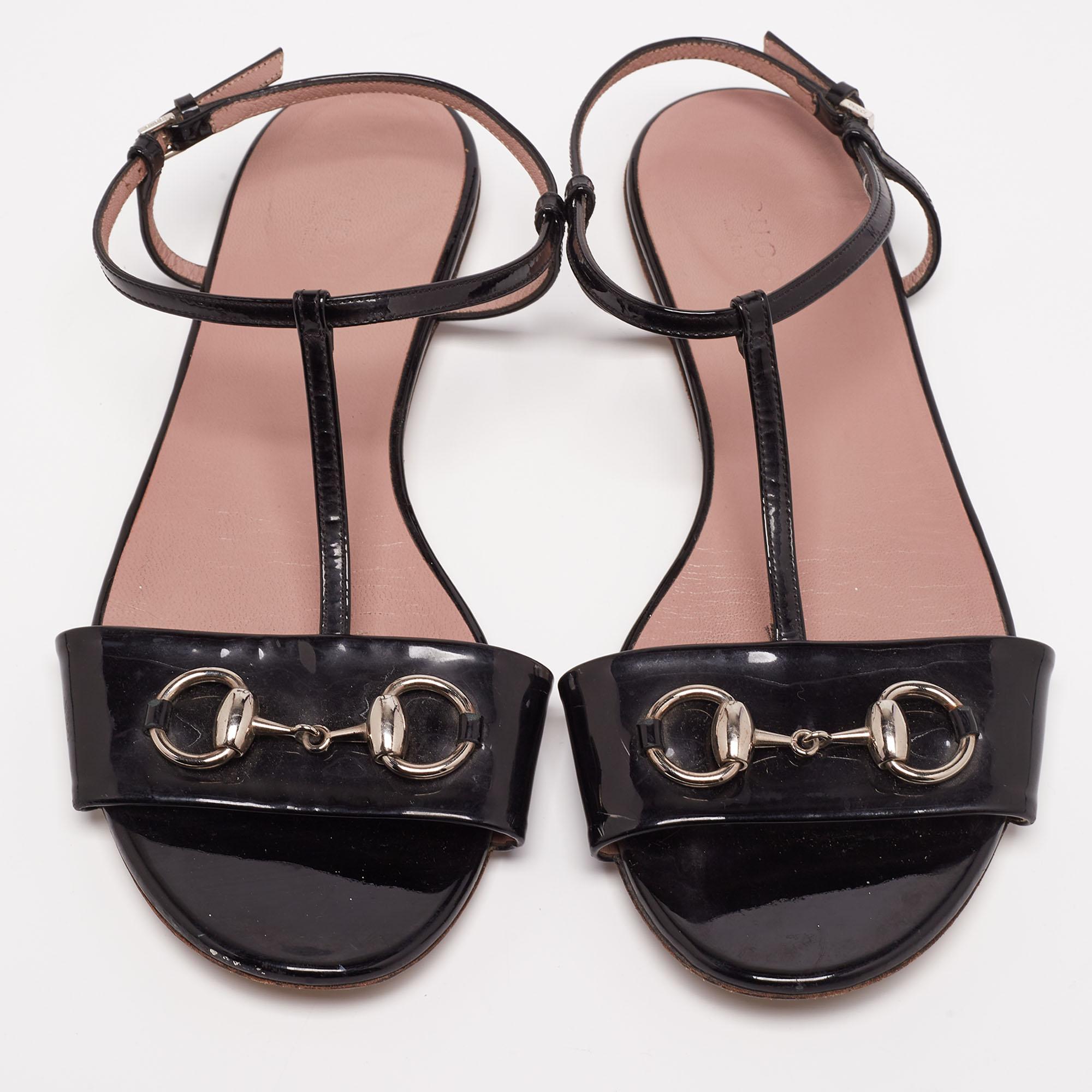 Designed to keep your steps light and stylish, these Gucci flats are made using patent leather. They feature open toes, Horsebit accents on the uppers, and buckle closure around the ankles. The black flats will be a great option on any